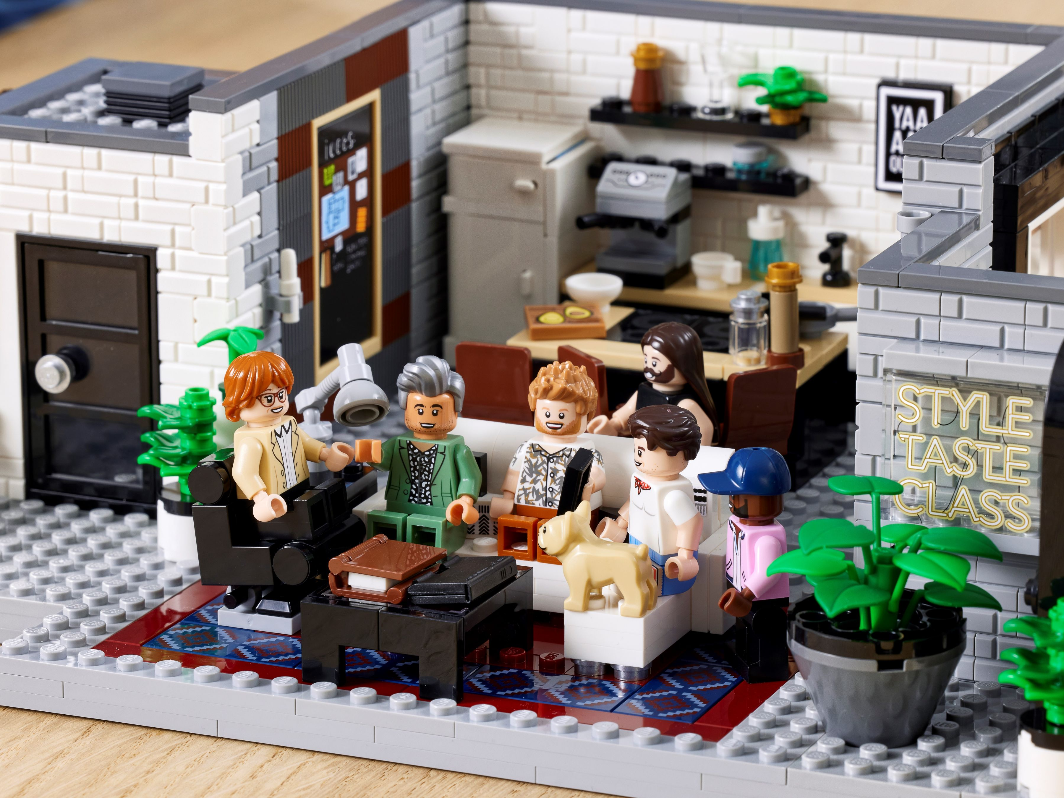 Lego-Nachbau eines Cafés mit sechs Figuren, einem Hund und Möbeln.