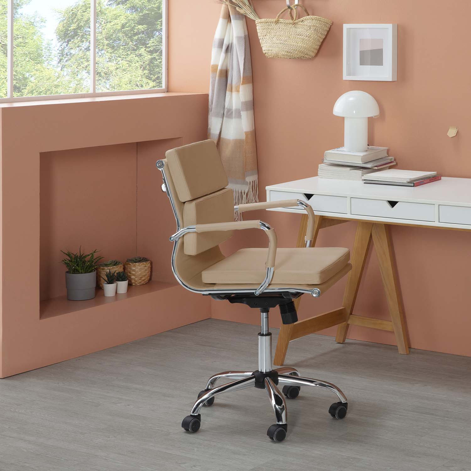 Silla de oficina color canela frente a escritorio con lámpara de seta. Plantas en estante.