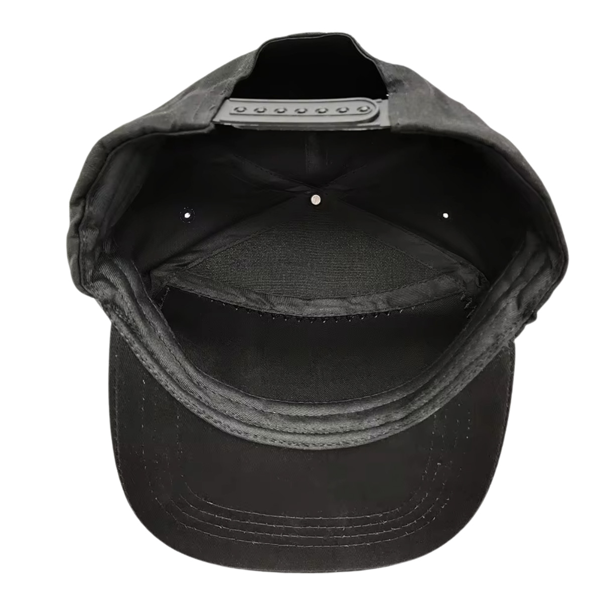 Vista superior de una gorra negra con correa ajustable y costuras.