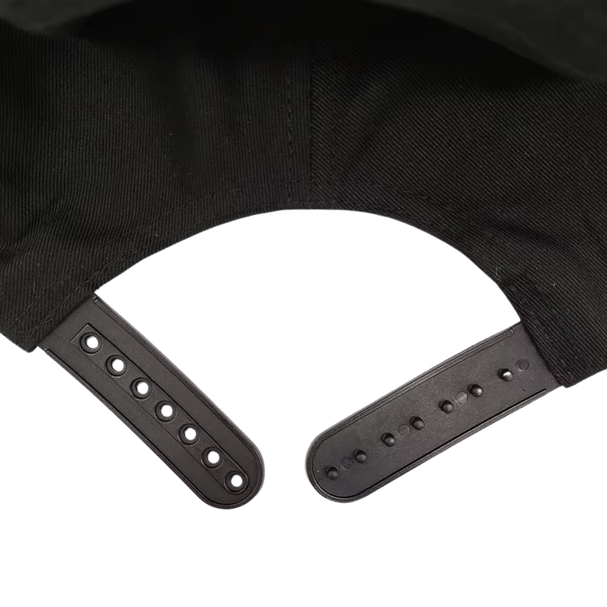 La parte trasera de una gorra negra con correa ajustable y agujeros.