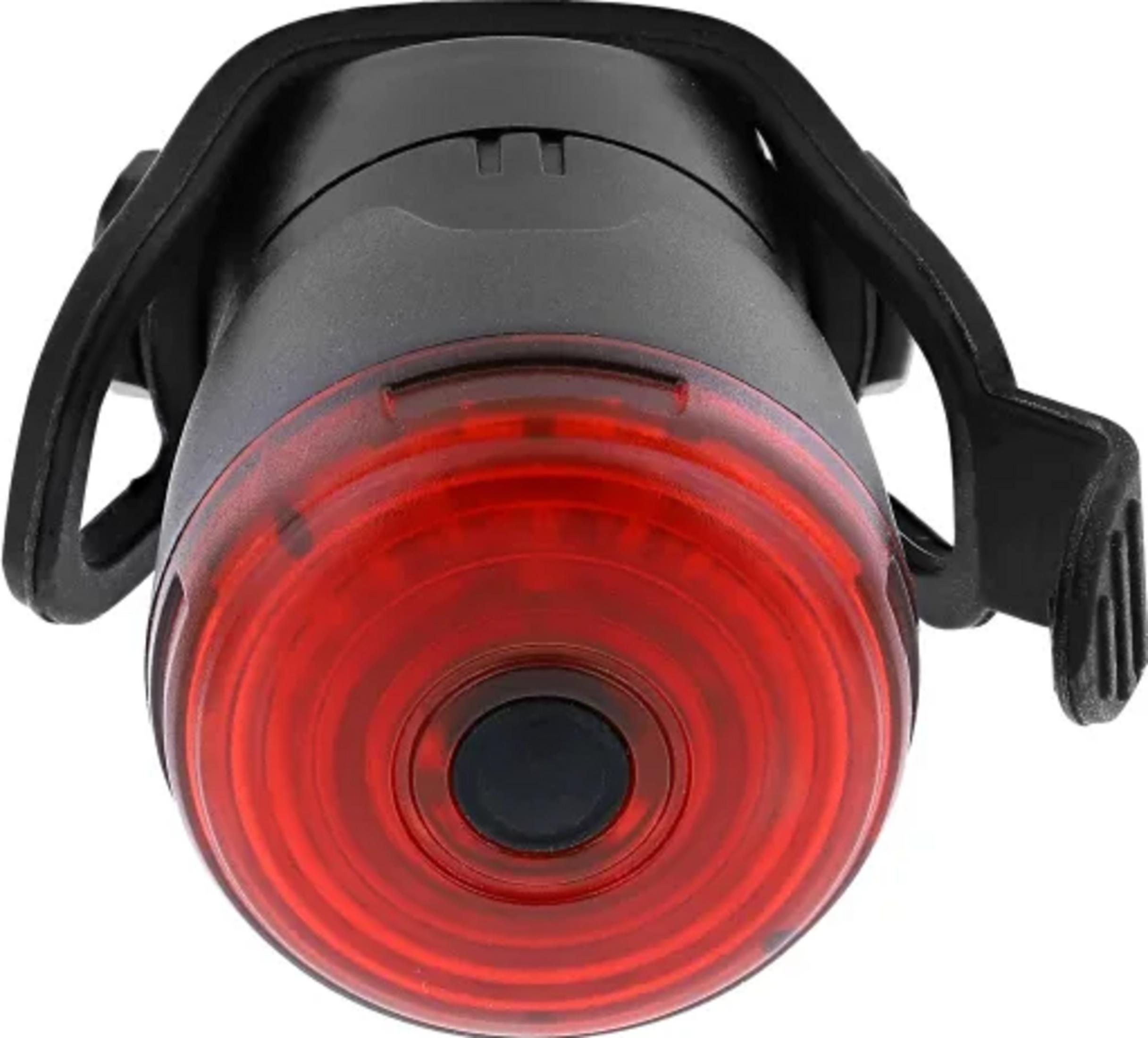 Ein rotes Fahrradrücklicht mit schwarzer Halterung, Nahaufnahme.