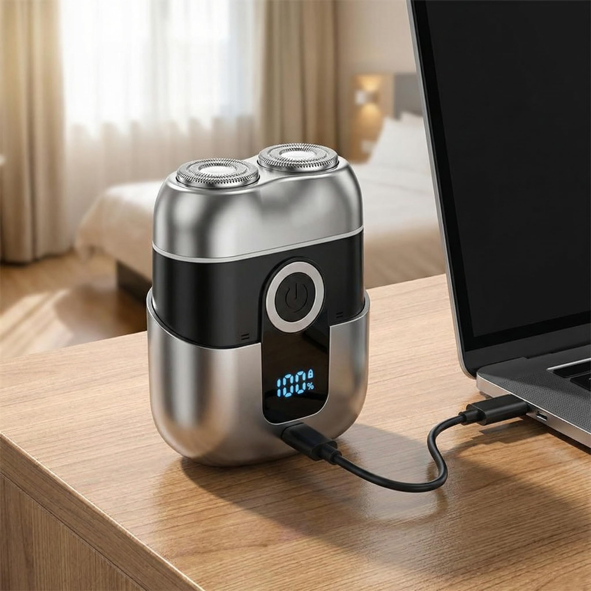 Elektrorasierer mit Ladeanzeige 100% neben Laptop, lädt auf Holztisch.