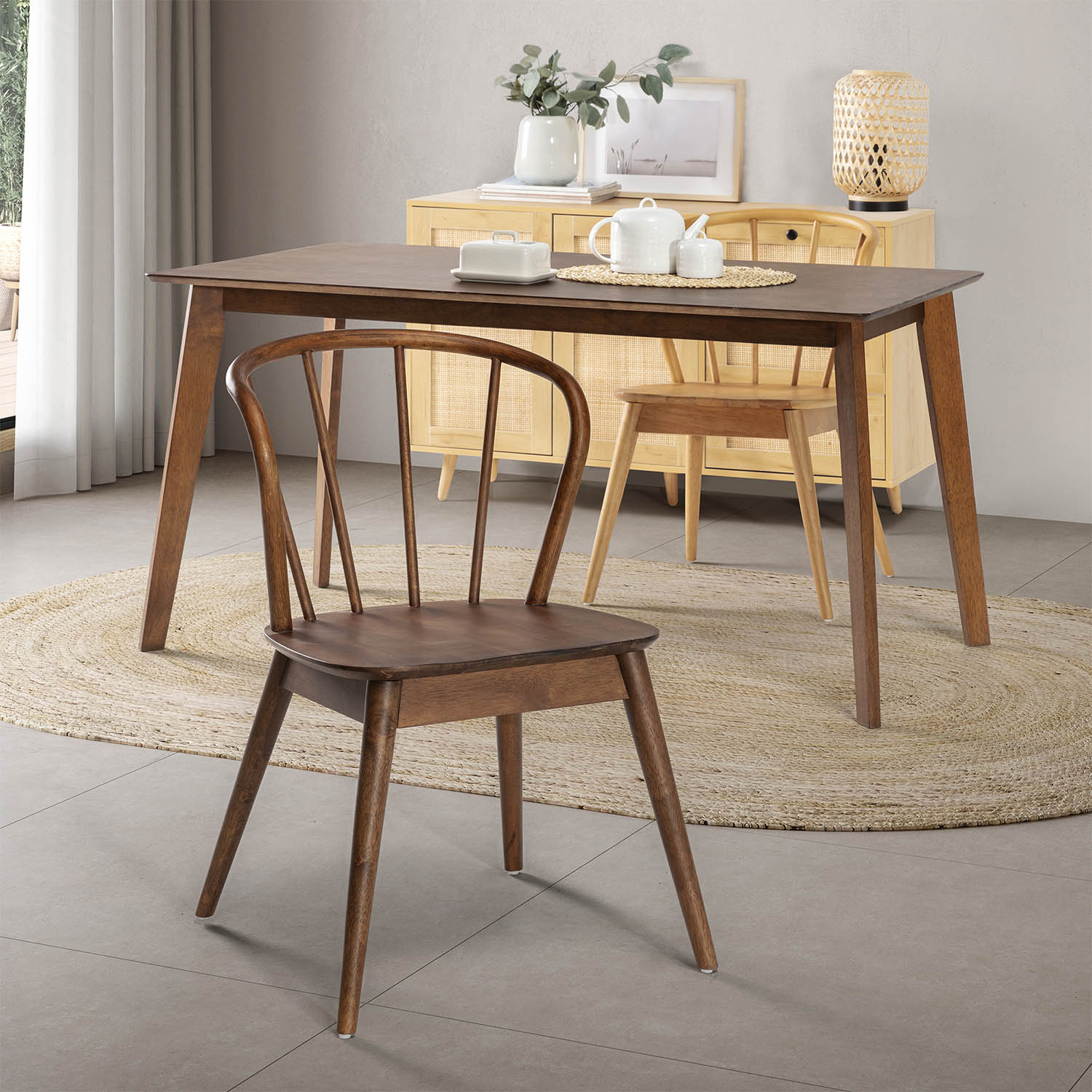 Un comedor con mesa de madera, sillas y un aparador con decoración.