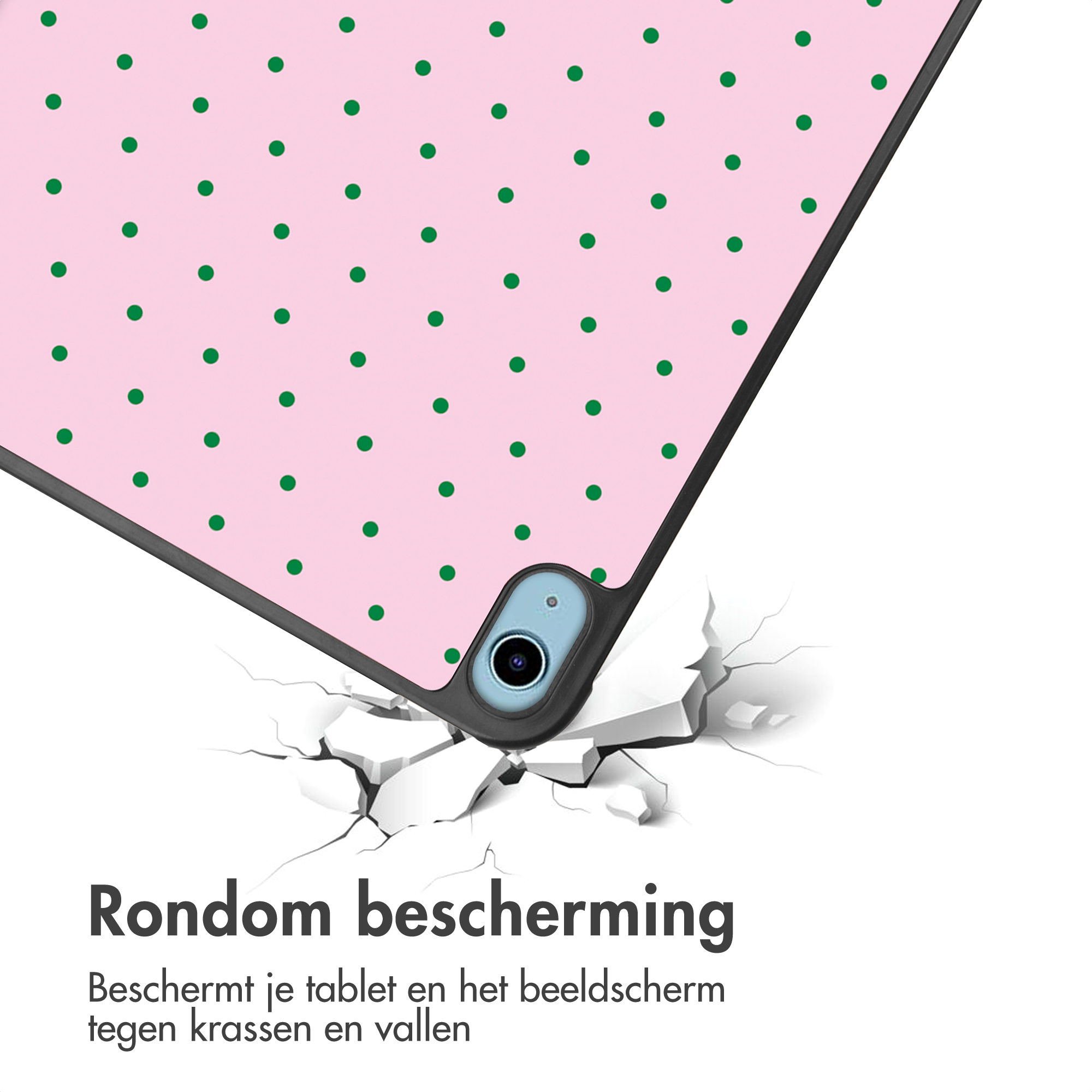 Een roze tablethoes met groene stippen valt op gebarsten grond.