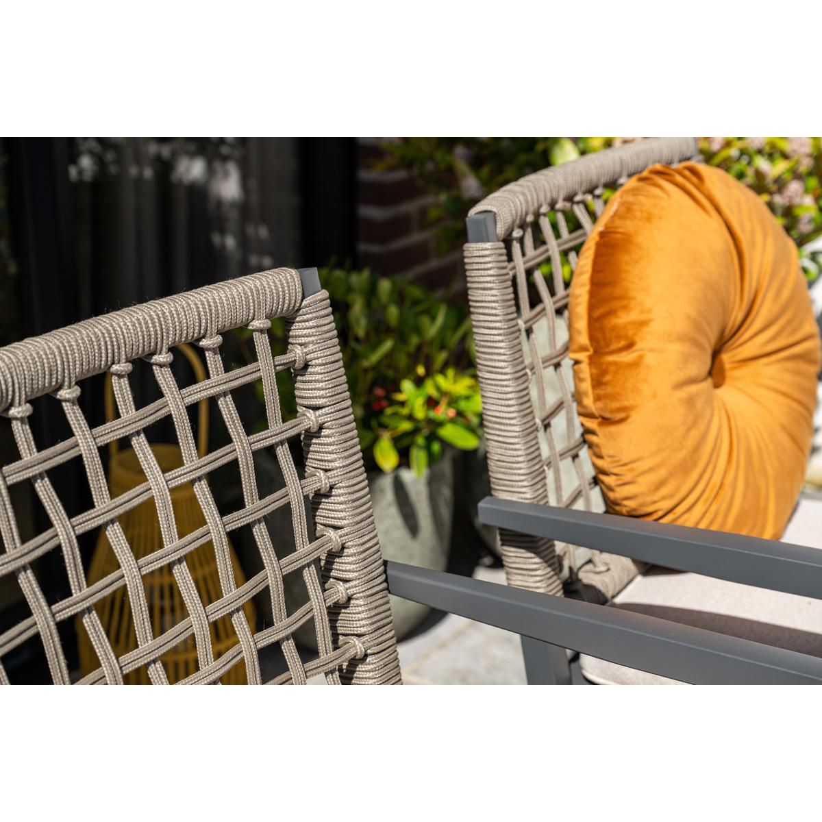 Two outdoor chairs with woven rope backs and an orange cushion.