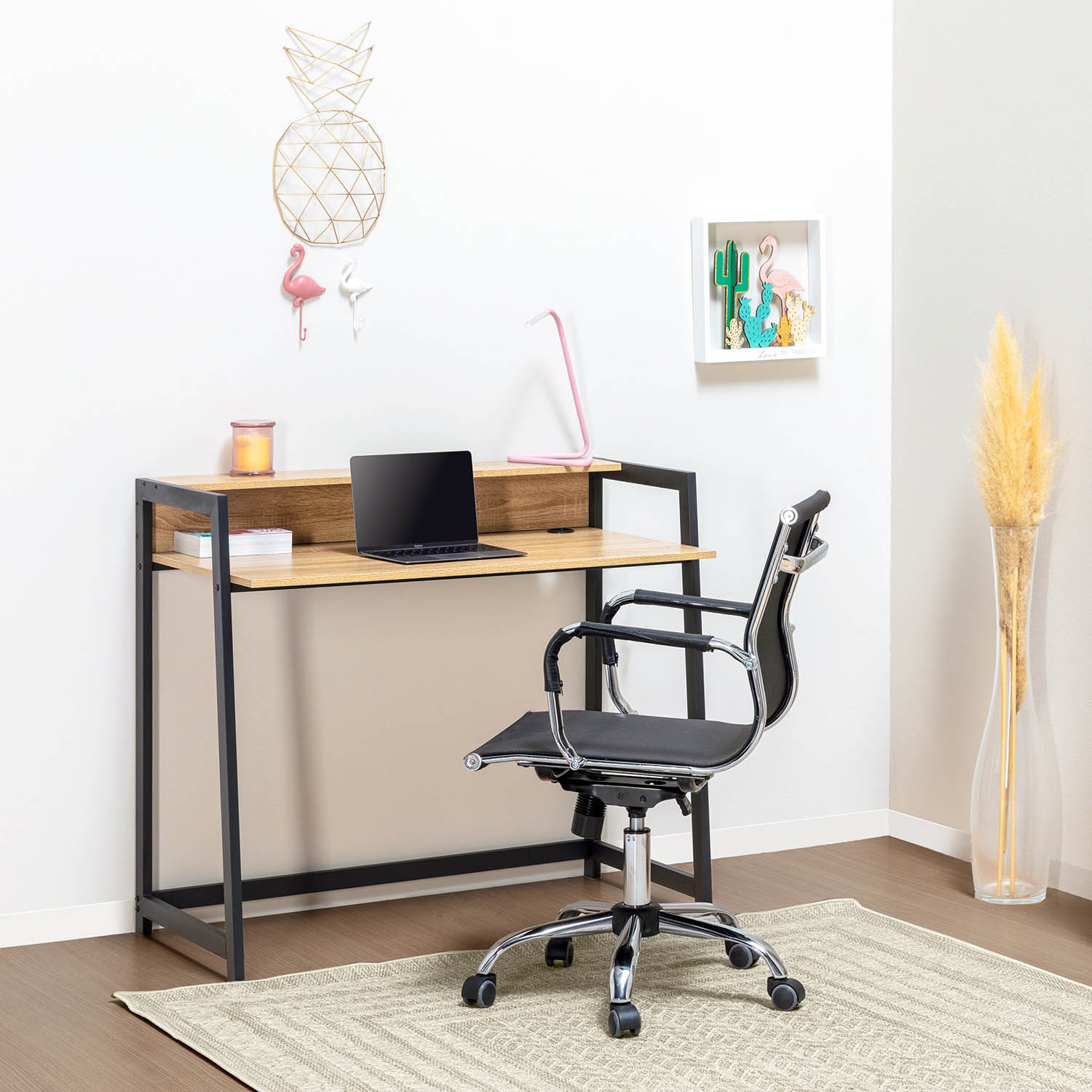 Un escritorio moderno con laptop, silla y artículos decorativos sobre una alfombra.