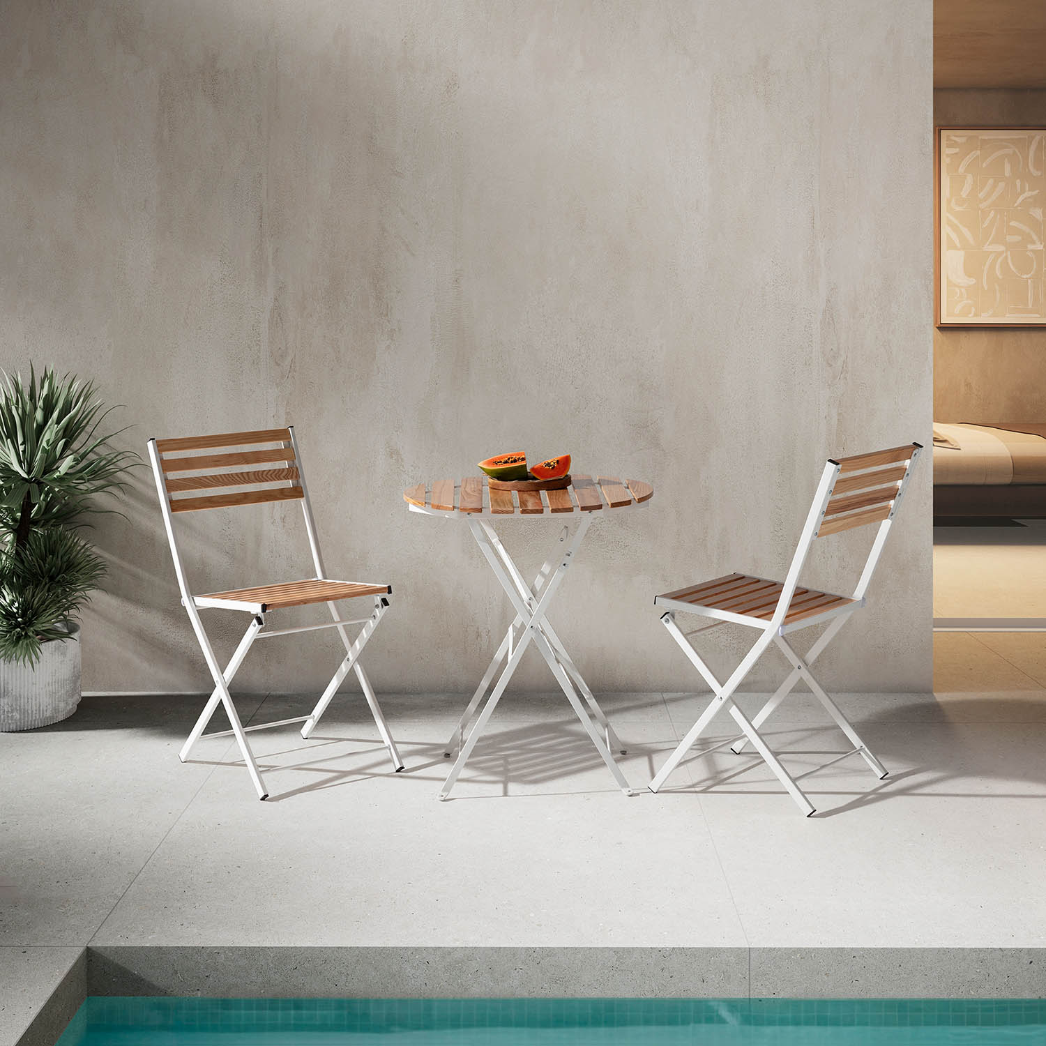 Dos sillas plegables blancas y una mesa redonda de madera con fruta afuera.