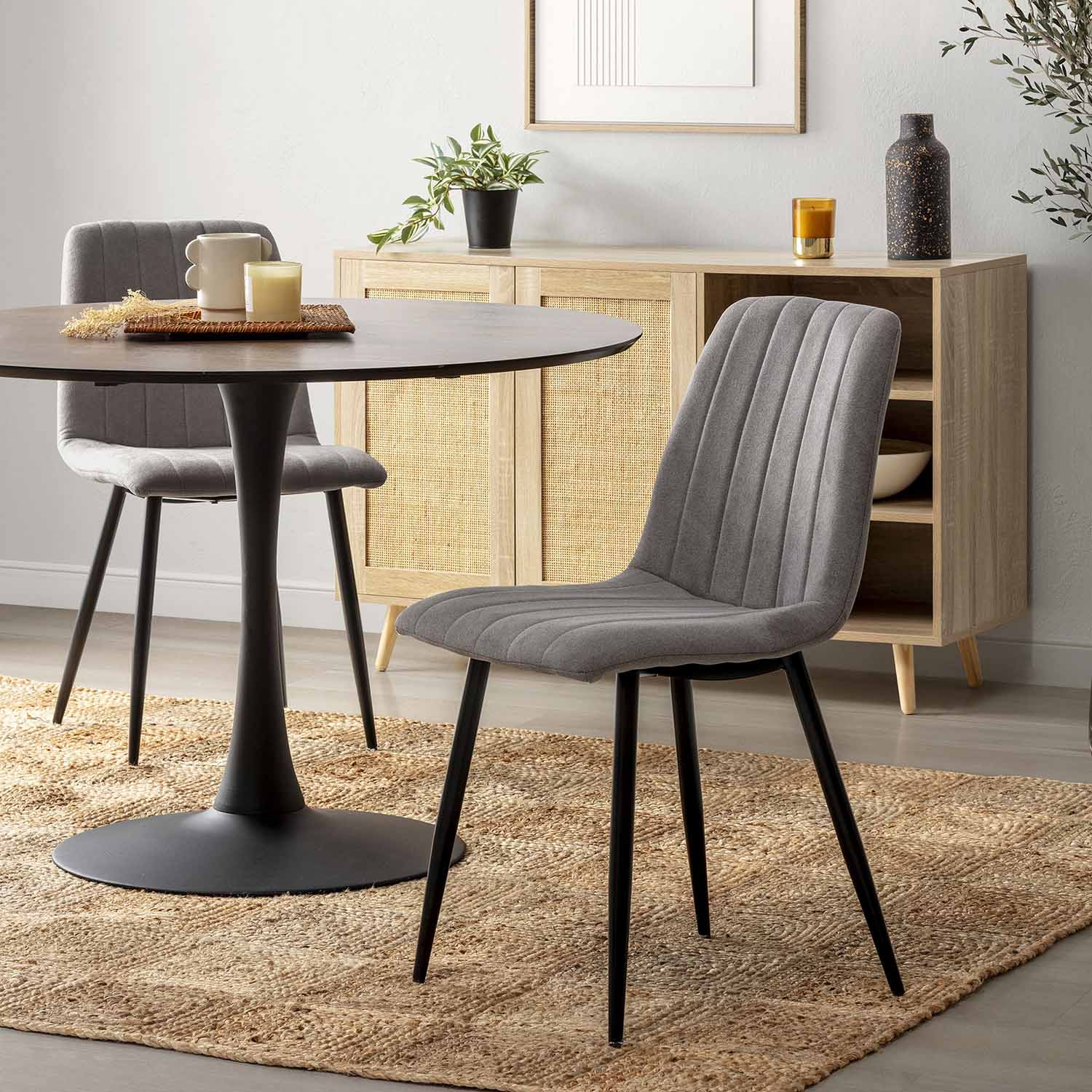 Conjunto de comedor moderno con sillas grises, mesa tulipán negra y aparador de madera.