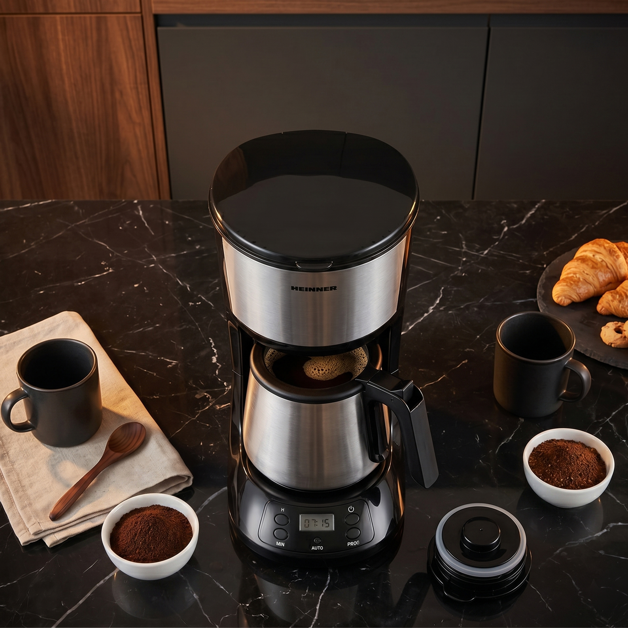 Cafetière avec verseuse, tasses, marc de café, croissants sur table en marbre.