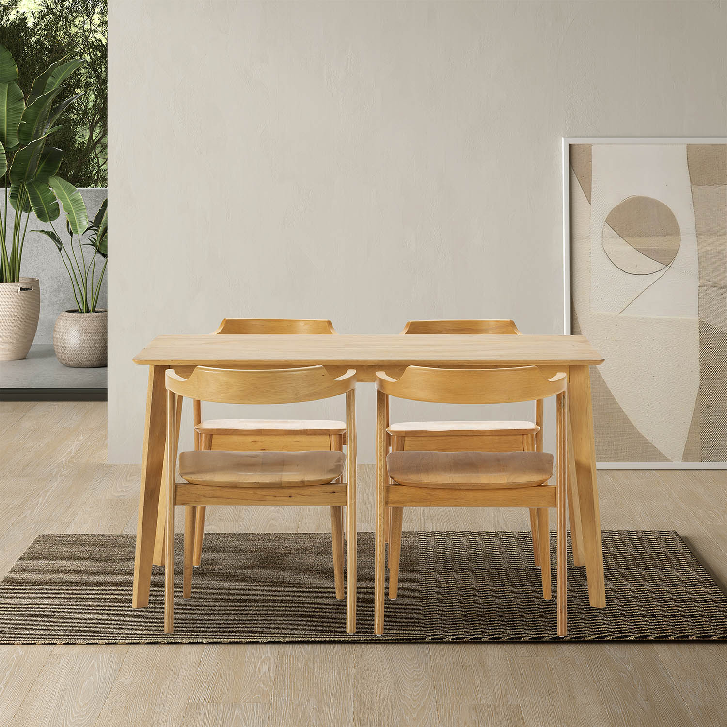 Una mesa de madera con cuatro sillas sobre una alfombra frente a una pared clara.