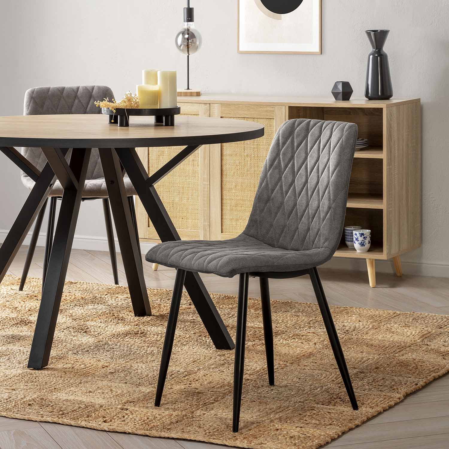 Una mesa de comedor con sillas, alfombra y aparador en un comedor moderno.