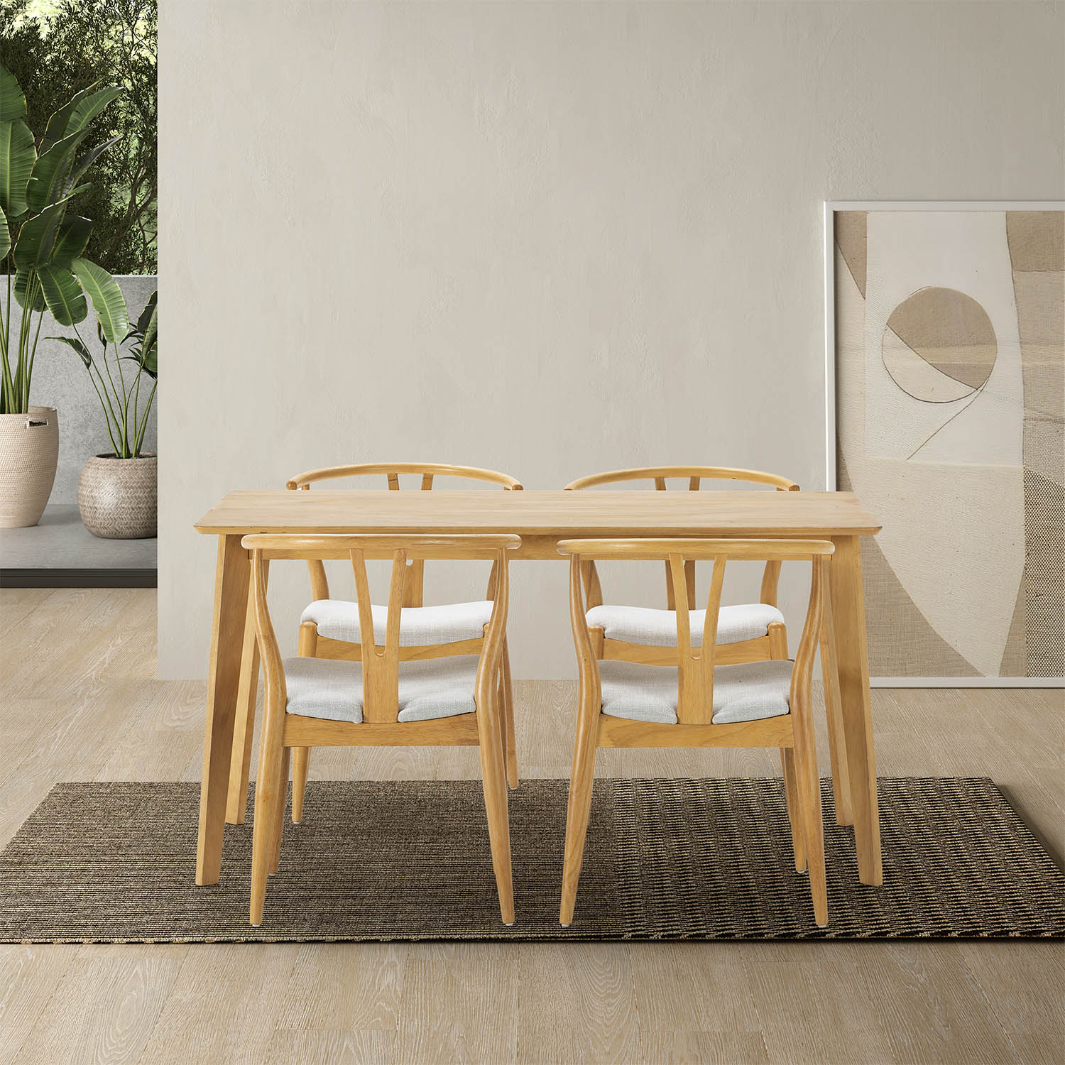 Una mesa de madera con cuatro sillas con cojines blancos se asienta sobre una alfombra oscura.