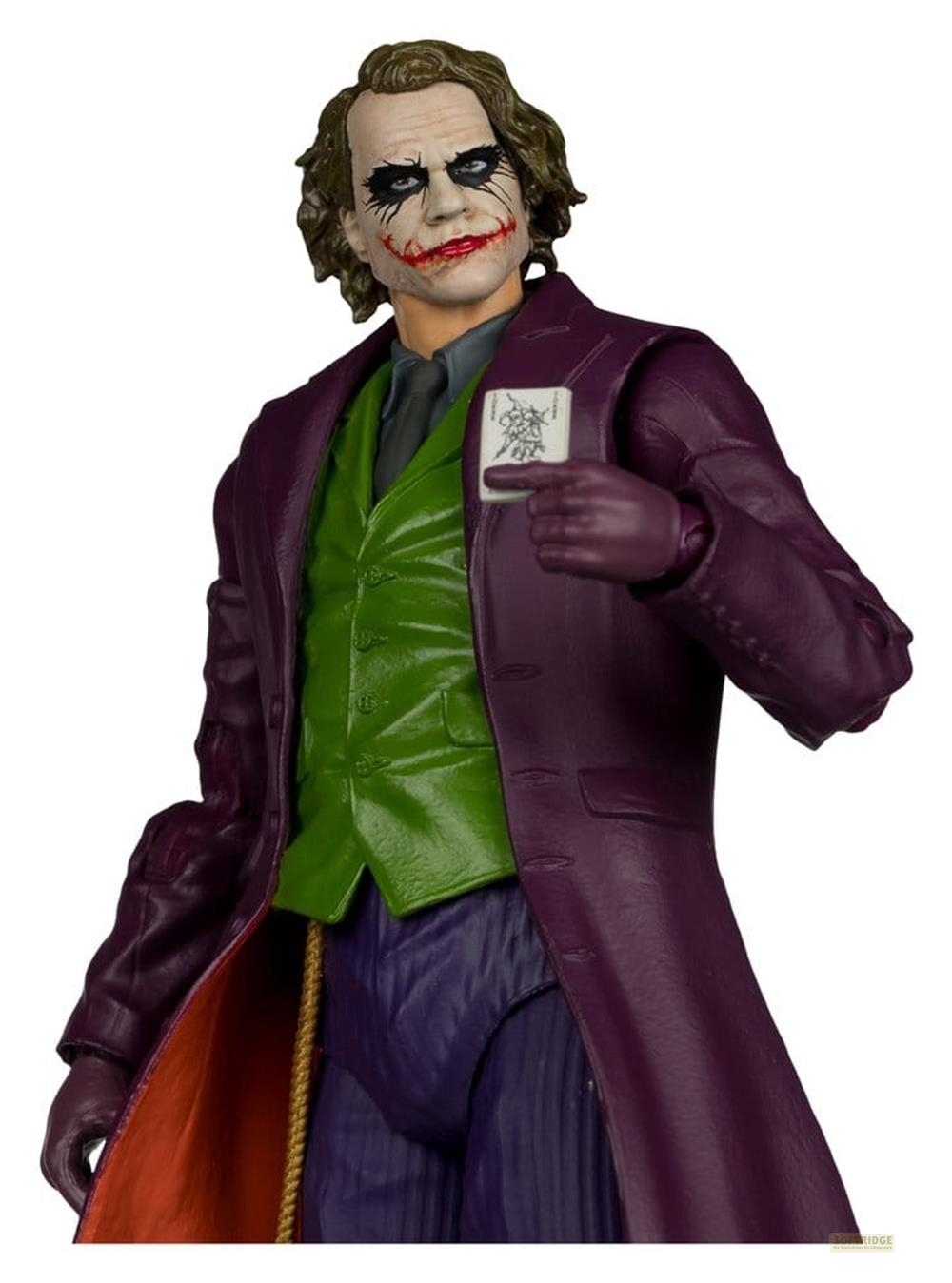 Eine Figur des Jokers in lila Mantel, grüne Weste, lila Hose und mit einer Spielkarte.