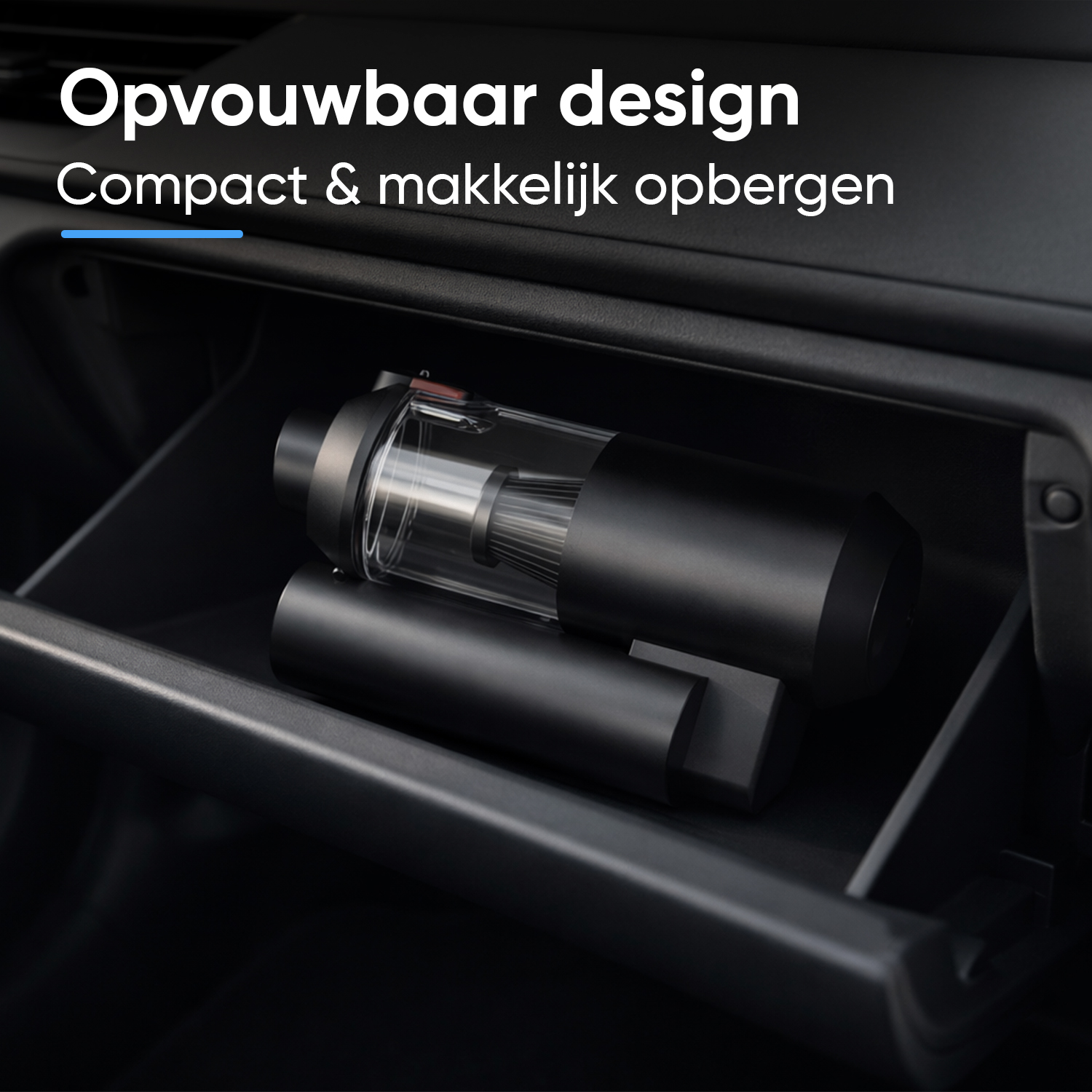 Black, compact vacuum cleaner lies in a dark car glove compartment.