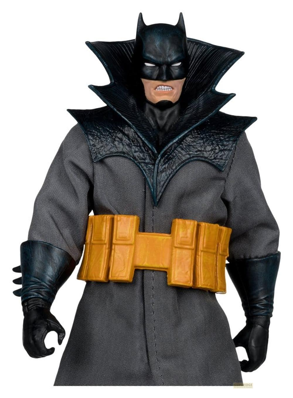 Una figura de acción de Batman lleva un abrigo gris, cinturón amarillo y guantes negros.