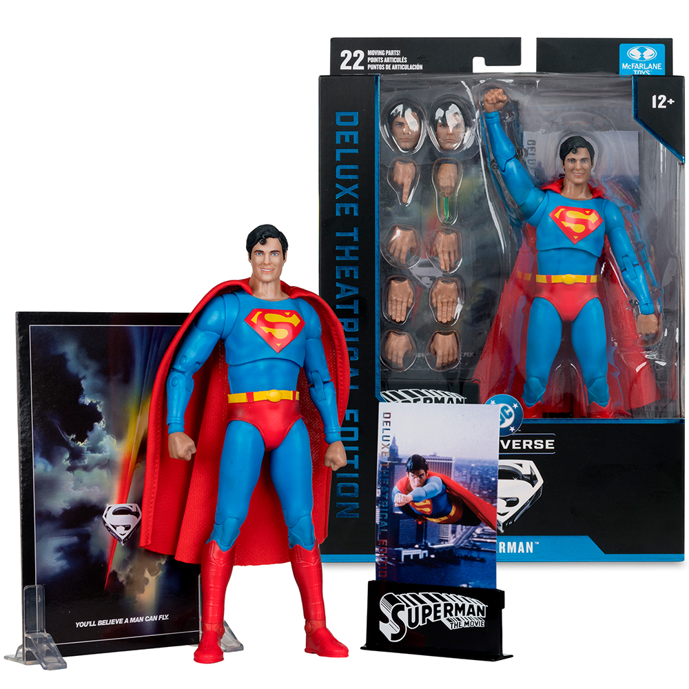 Superman-Actionfigur mit Zubehör und Verpackung. Die Figur trägt das ikonische blaue Kostüm.