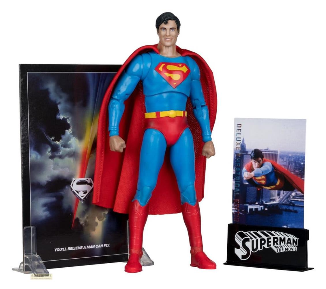 Eine Superman-Figur steht vor einem Poster mit dem S-Symbol und dem Satz 'You'll believe a man can fly'.