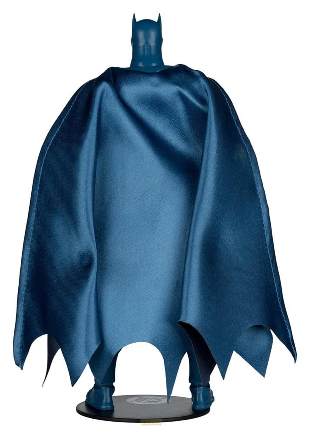 Vista trasera de una figura de Batman con capa azul sobre un soporte negro.