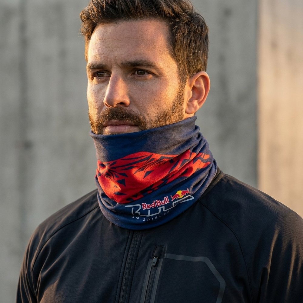 Uomo con barba indossa scaldacollo blu scuro con disegno rosso e logo Red Bull.