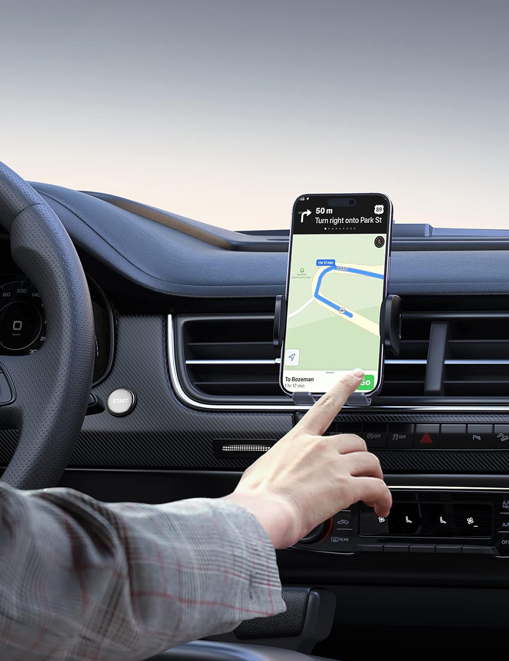 Mano che usa il telefono con app di navigazione all'interno di un'auto. Volante visibile.