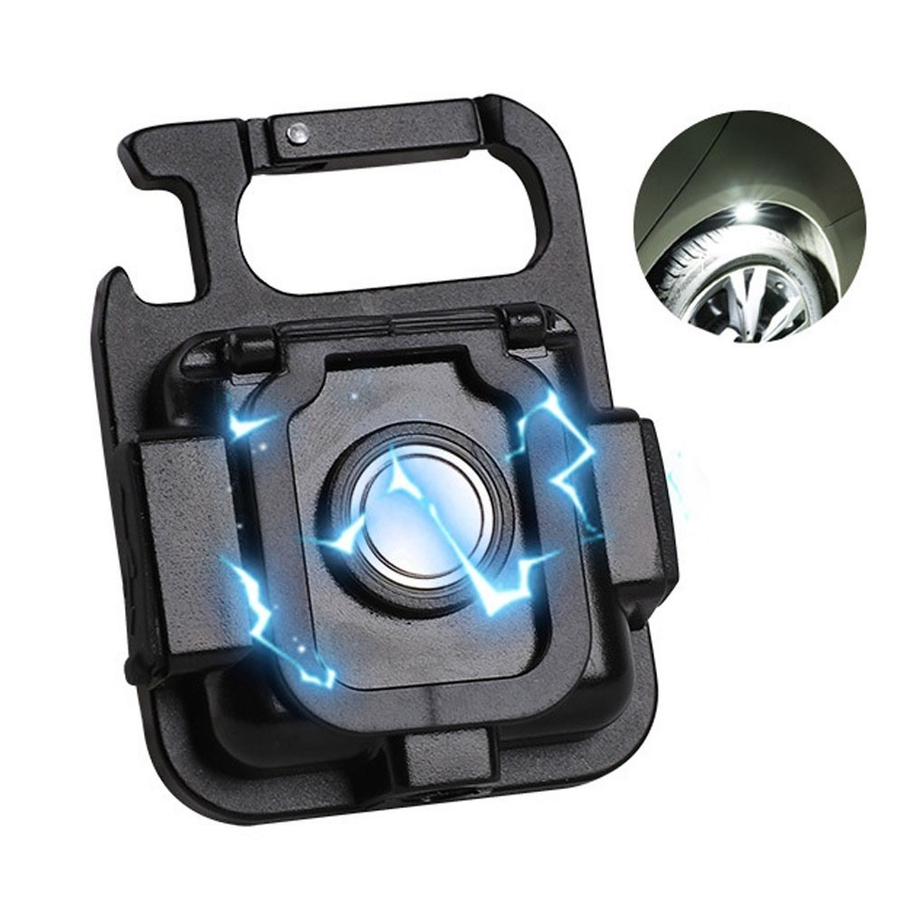 Schwarzes Multifunktionswerkzeug mit Karabiner und heller LED, die einen Autoreifen beleuchtet.