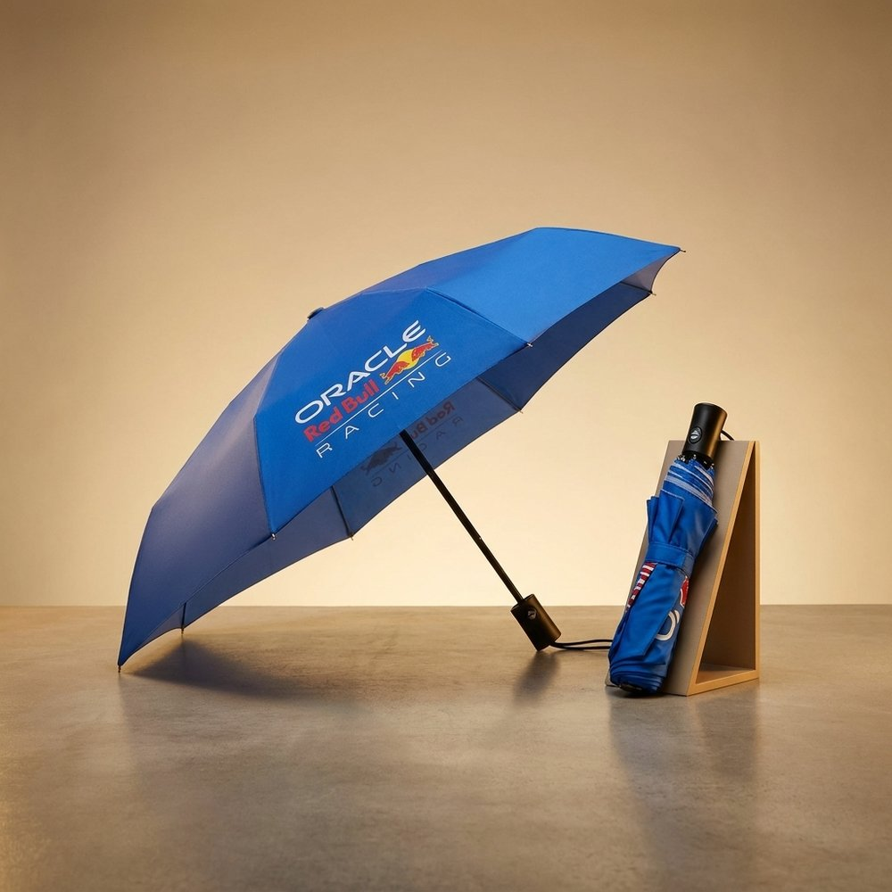 Un ombrello blu aperto con logo Red Bull Racing, accanto a uno chiuso.