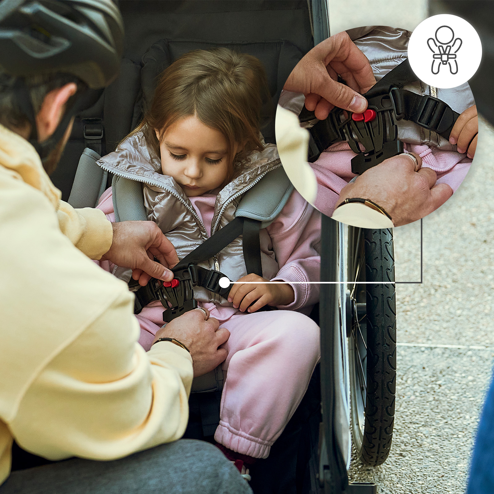 Mann schließt Kindersicherheitsgurt in einem Kinderwagen. Detailansicht des Gurtes.