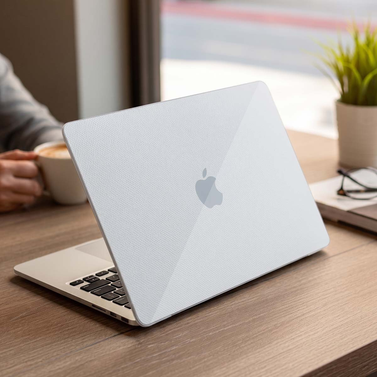 Un coperchio bianco MacBook con logo Apple su tavolo di legno.