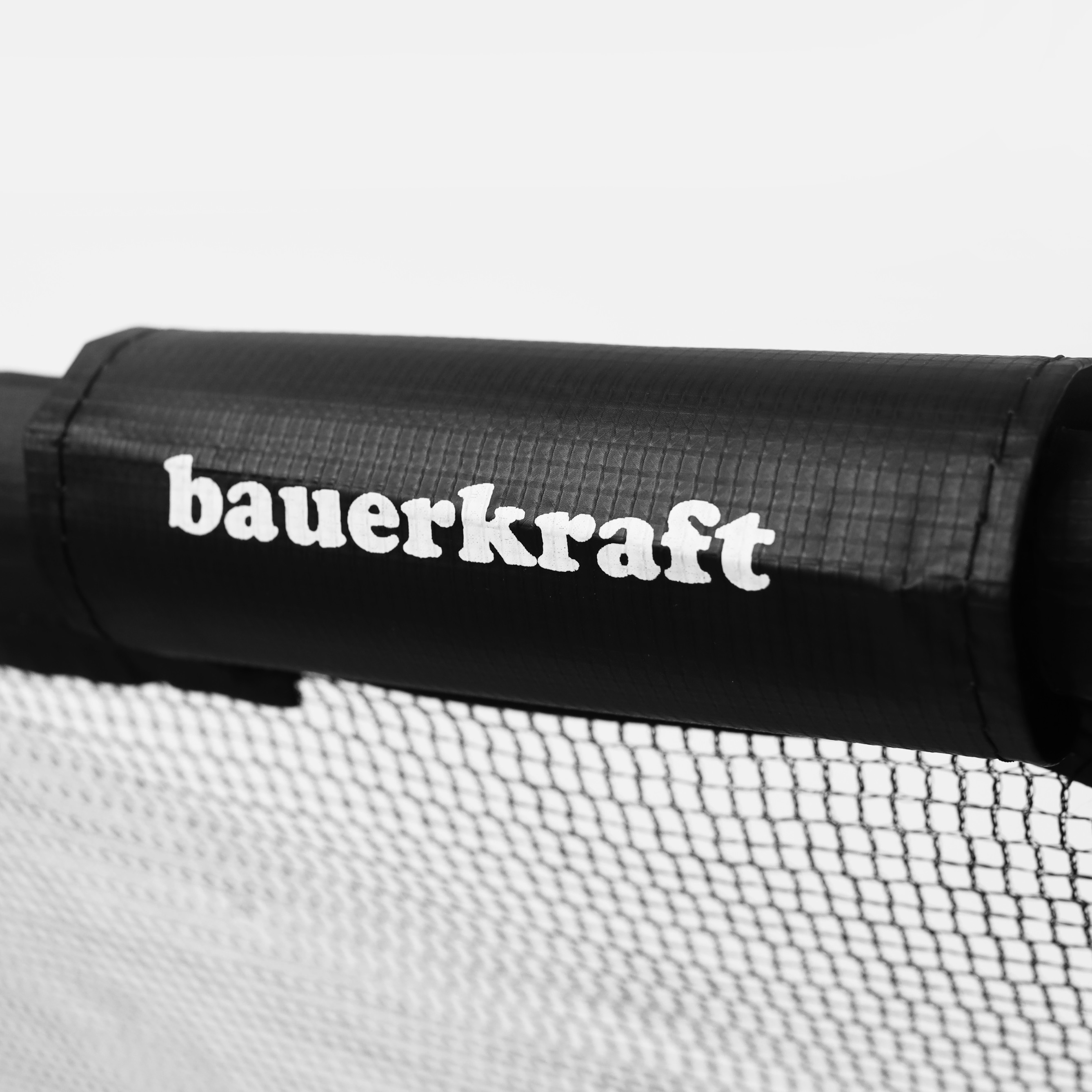 Czarny uchwyt z białym logo "bauer kraft" nad siatką.