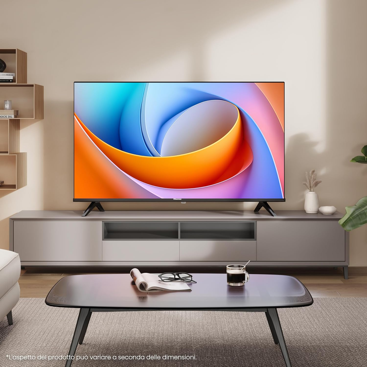 TV moderna su un mobile. Caffè e occhiali su un tavolo davanti.