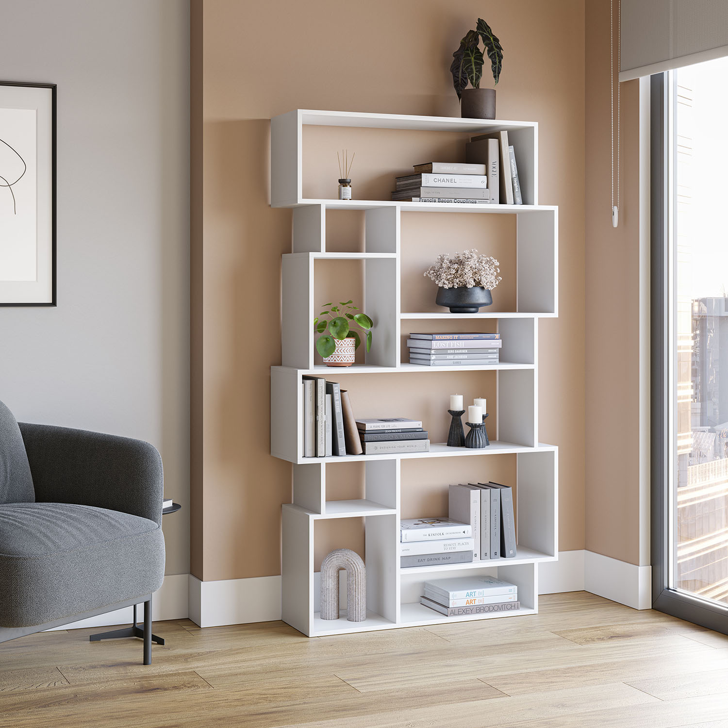 Una estantería blanca con libros, plantas y decoración.