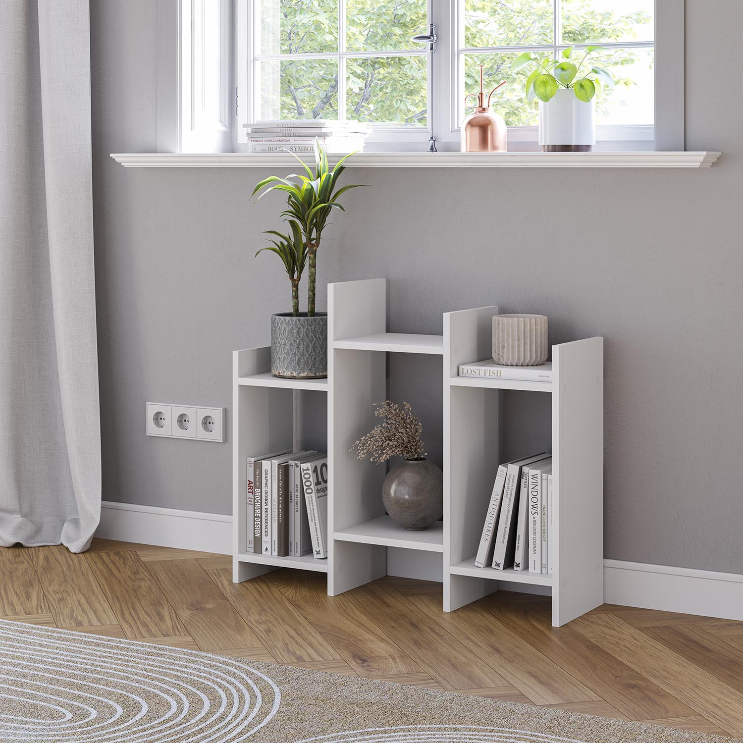 Un estante blanco con libros y plantas frente a una ventana.