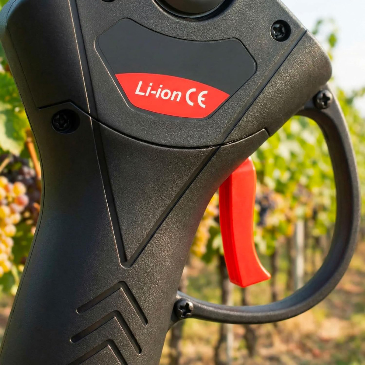 Herramienta negra con gatillo rojo y etiqueta "Li-ion CE", al aire libre.