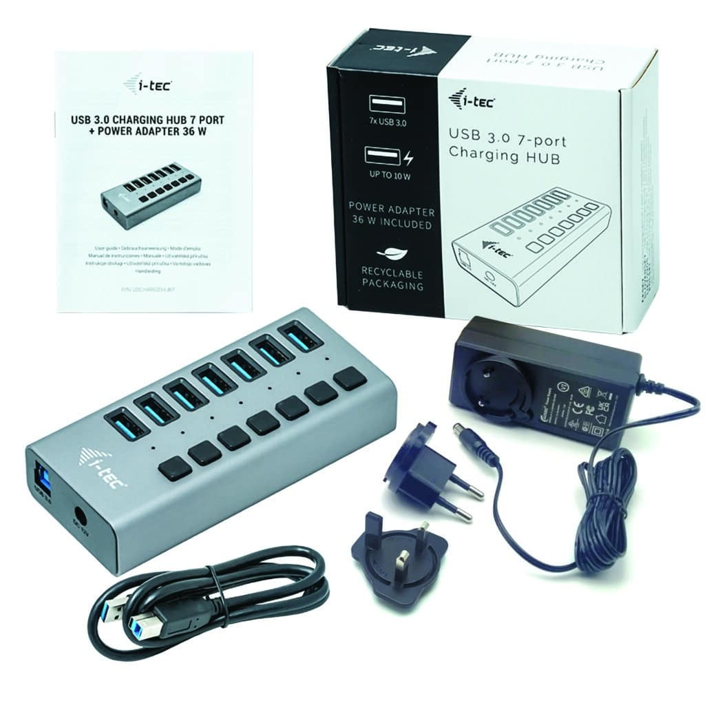 Hub USB 3.0 gris de 7 puertos con adaptador de carga, cables y manual.