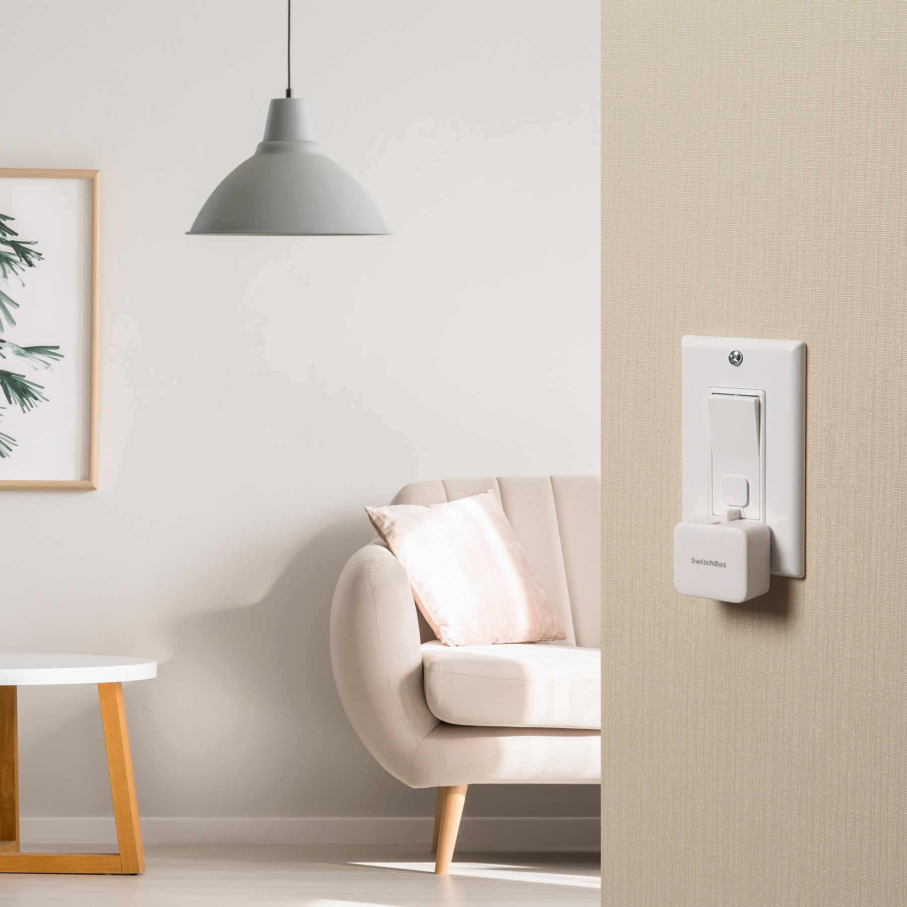 Ein heller Raum mit einem weißen Sofa, einem Beistelltisch und einer Lampe. Ein Lichtschalter mit Zusatzgerät.