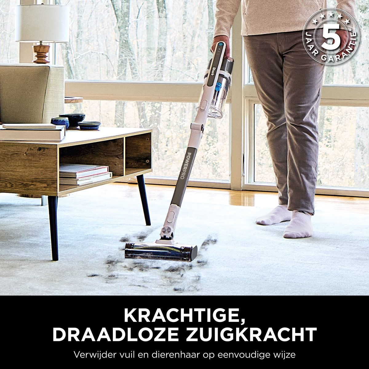 Een persoon stofzuigt een lichtgekleurd tapijt met een witte en grijze steelstofzuiger.