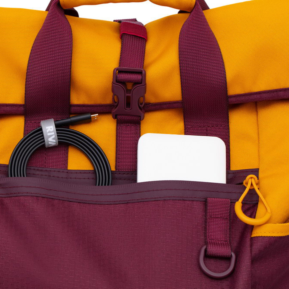 Borsa gialla e bordeaux con cavo nero e oggetto bianco in tasca.