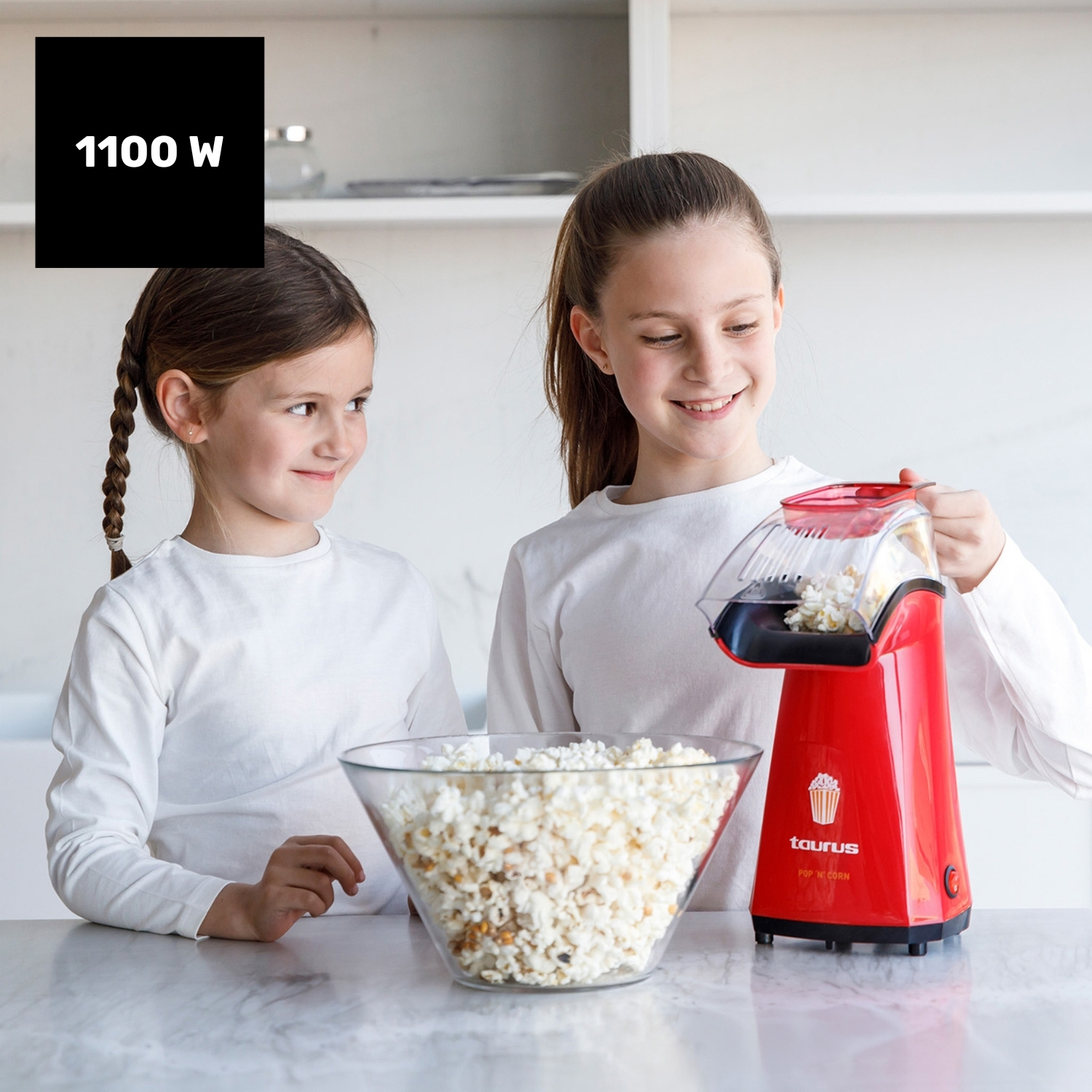 Dos niñas con máquina de palomitas y un bol de palomitas.