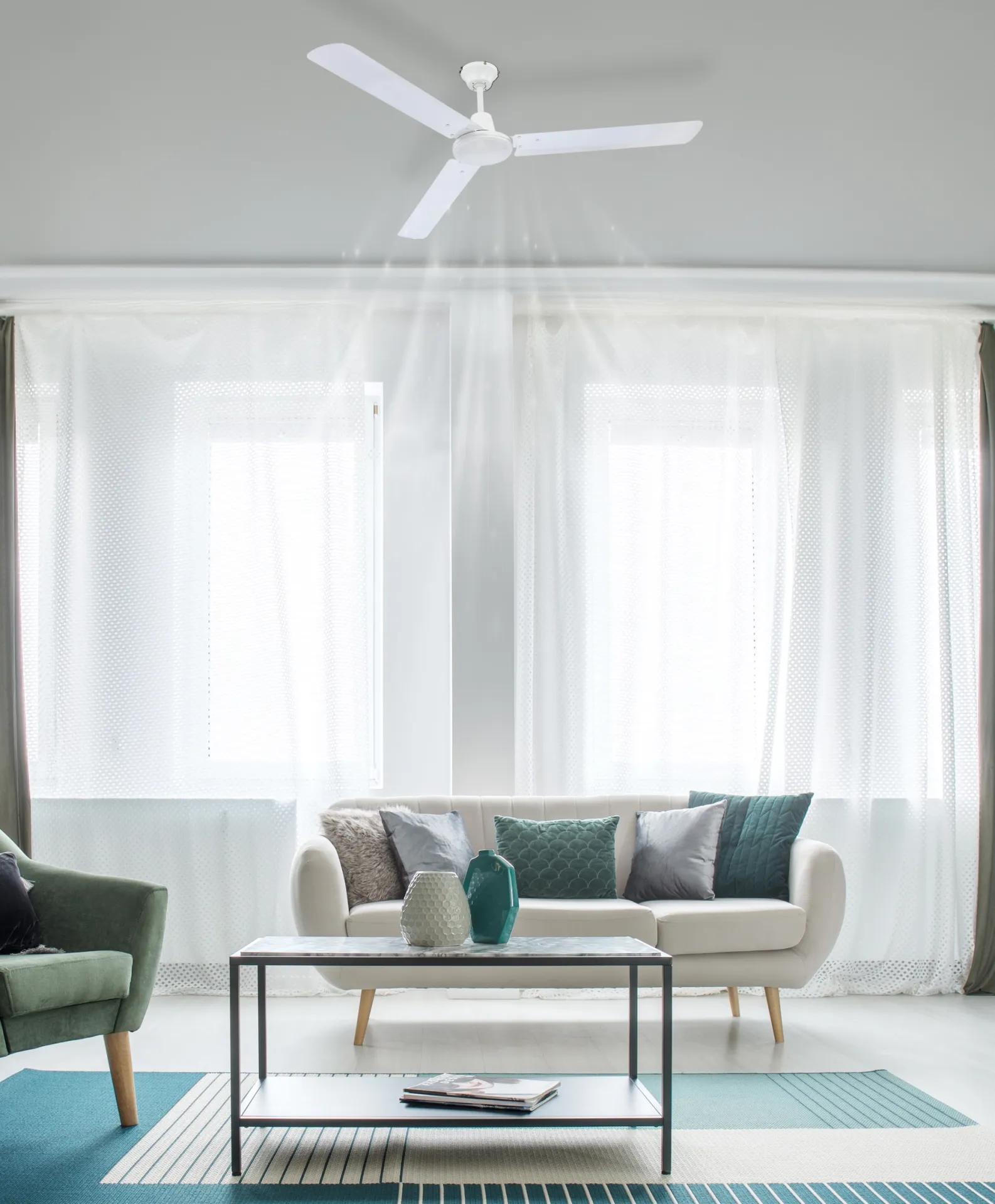 Ein weier Deckenventilator treibt Luft nach unten in ein Wohnzimmer.