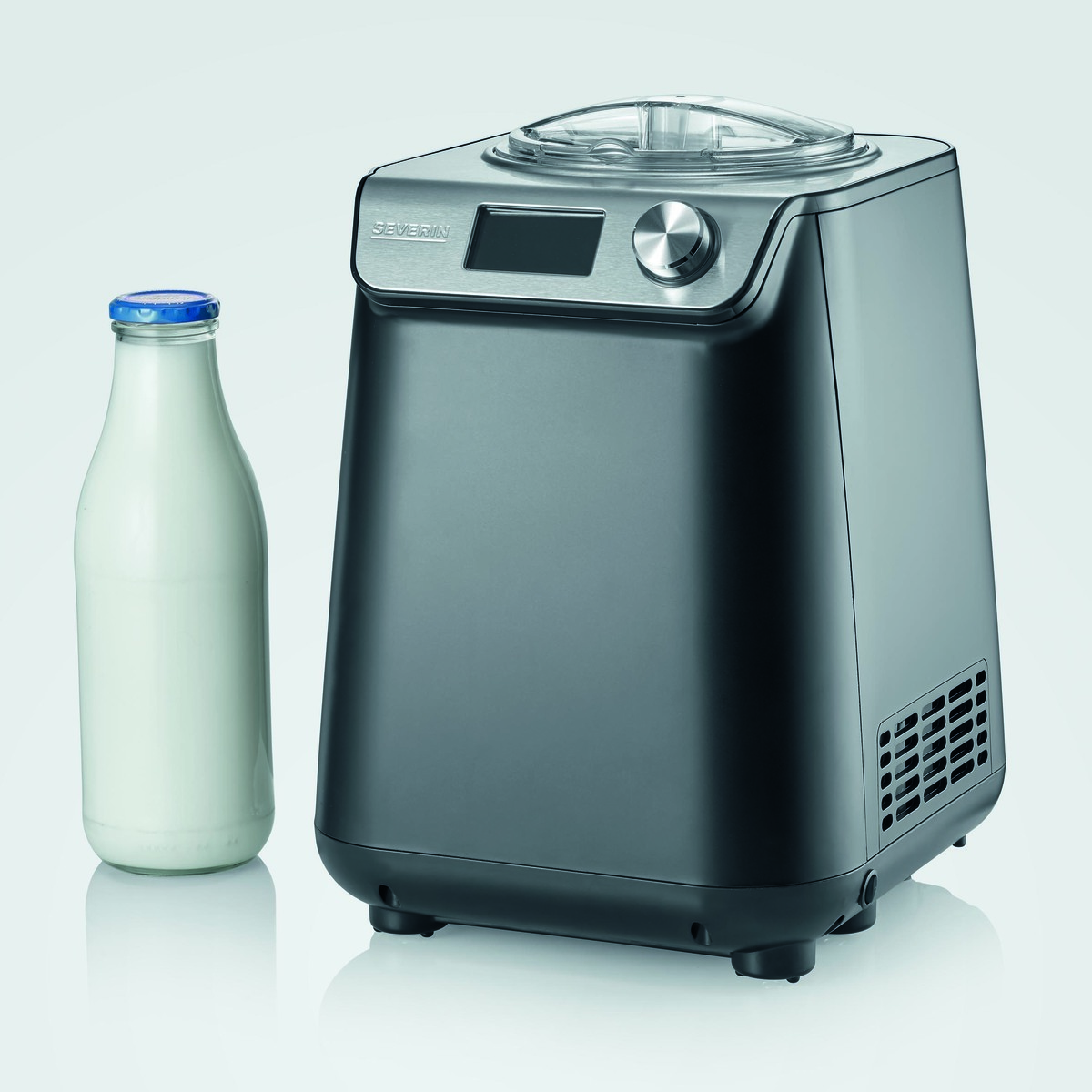 Une sorbetière noire à côté d'une bouteille de lait.