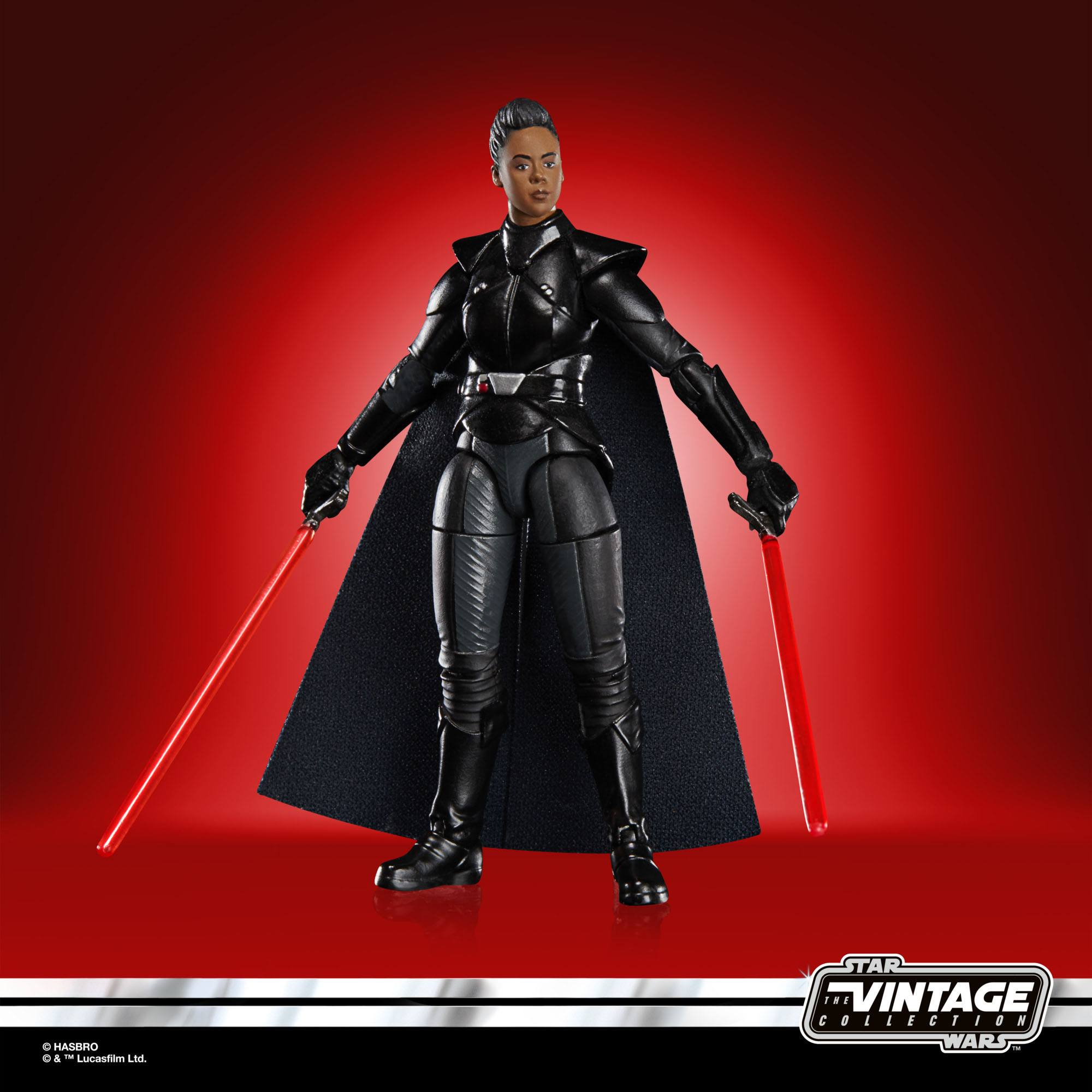 Action figure femminile in armatura nera tiene due spade laser rosse su sfondo rosso.