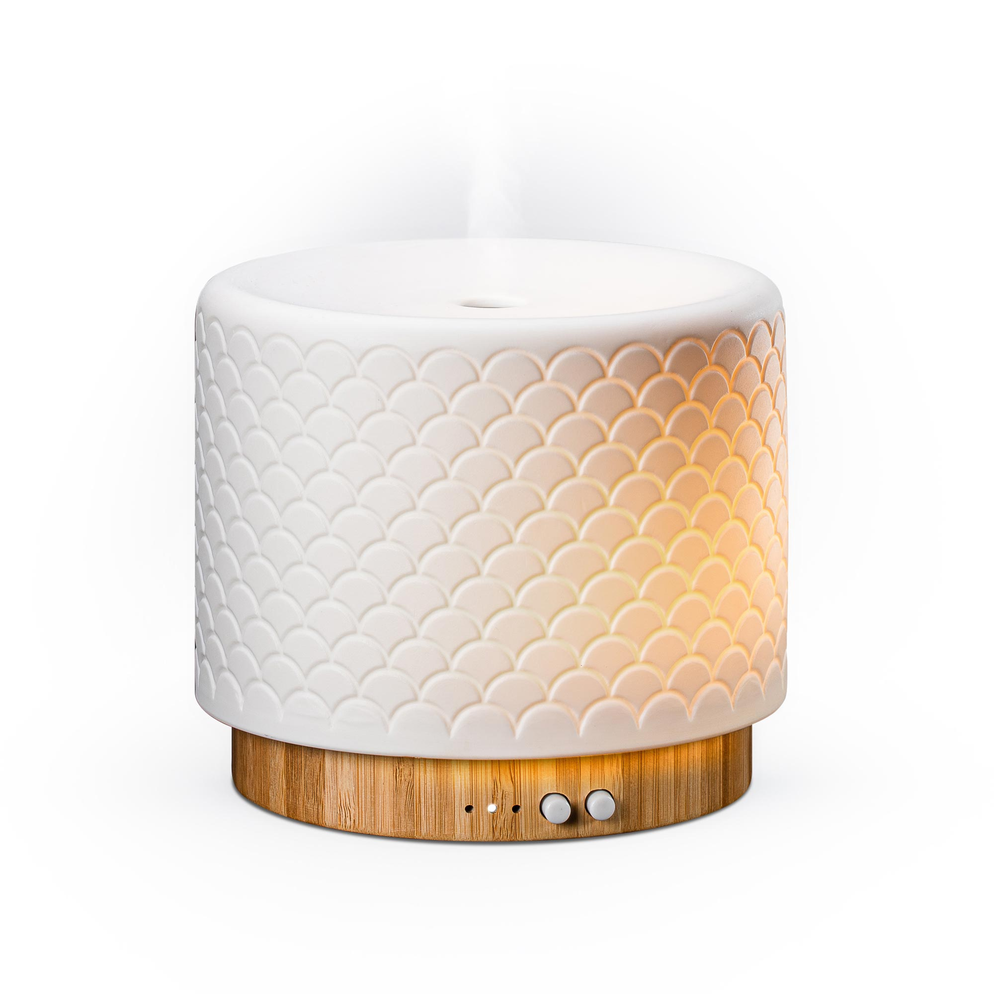 Ein weißer Diffusor mit Schuppenmuster auf Holzfuß. Leuchtet orange.