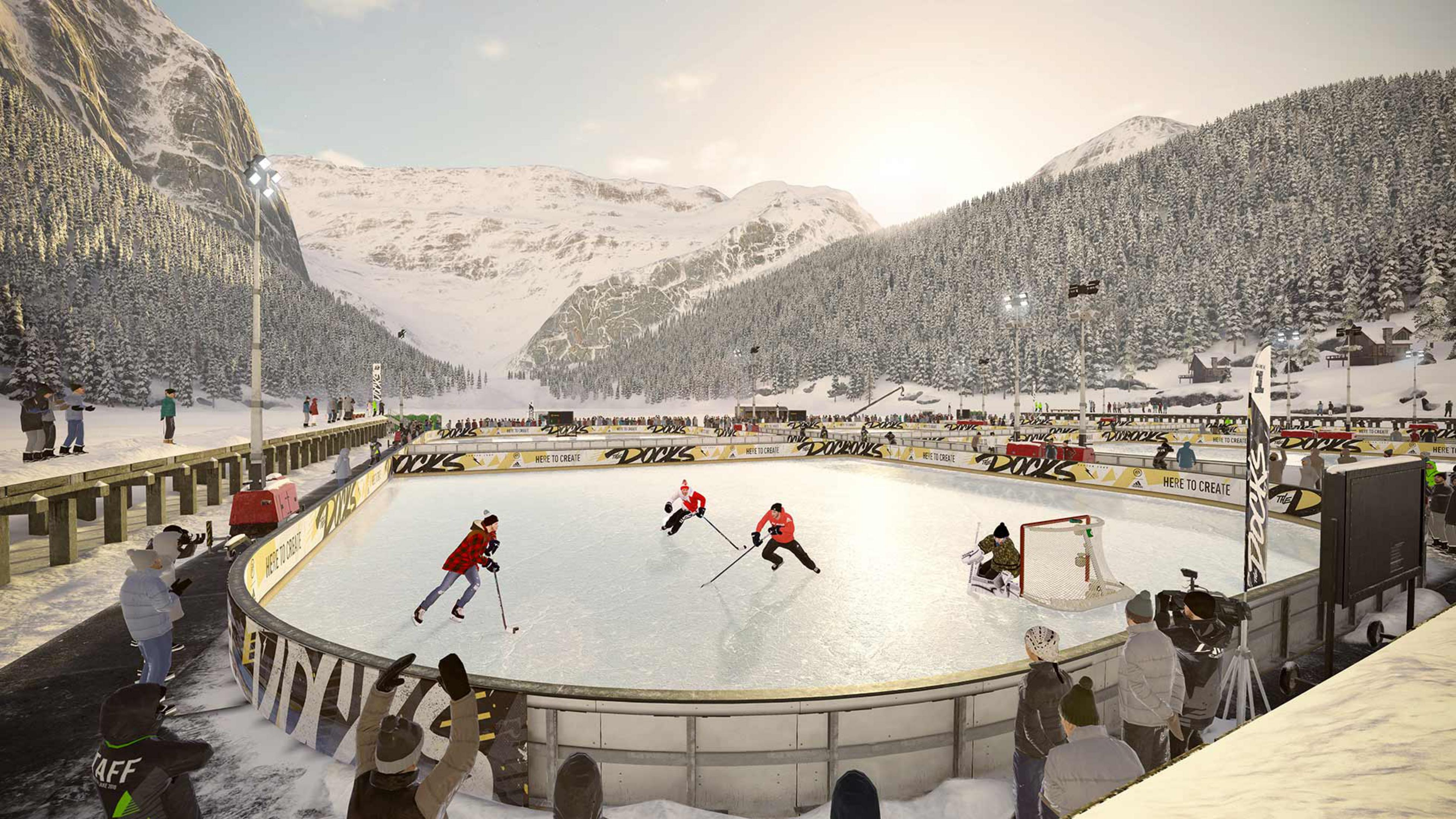 Eishockeyspiel in verschneiter Bergkulisse mit Zuschauern und Flutlicht.