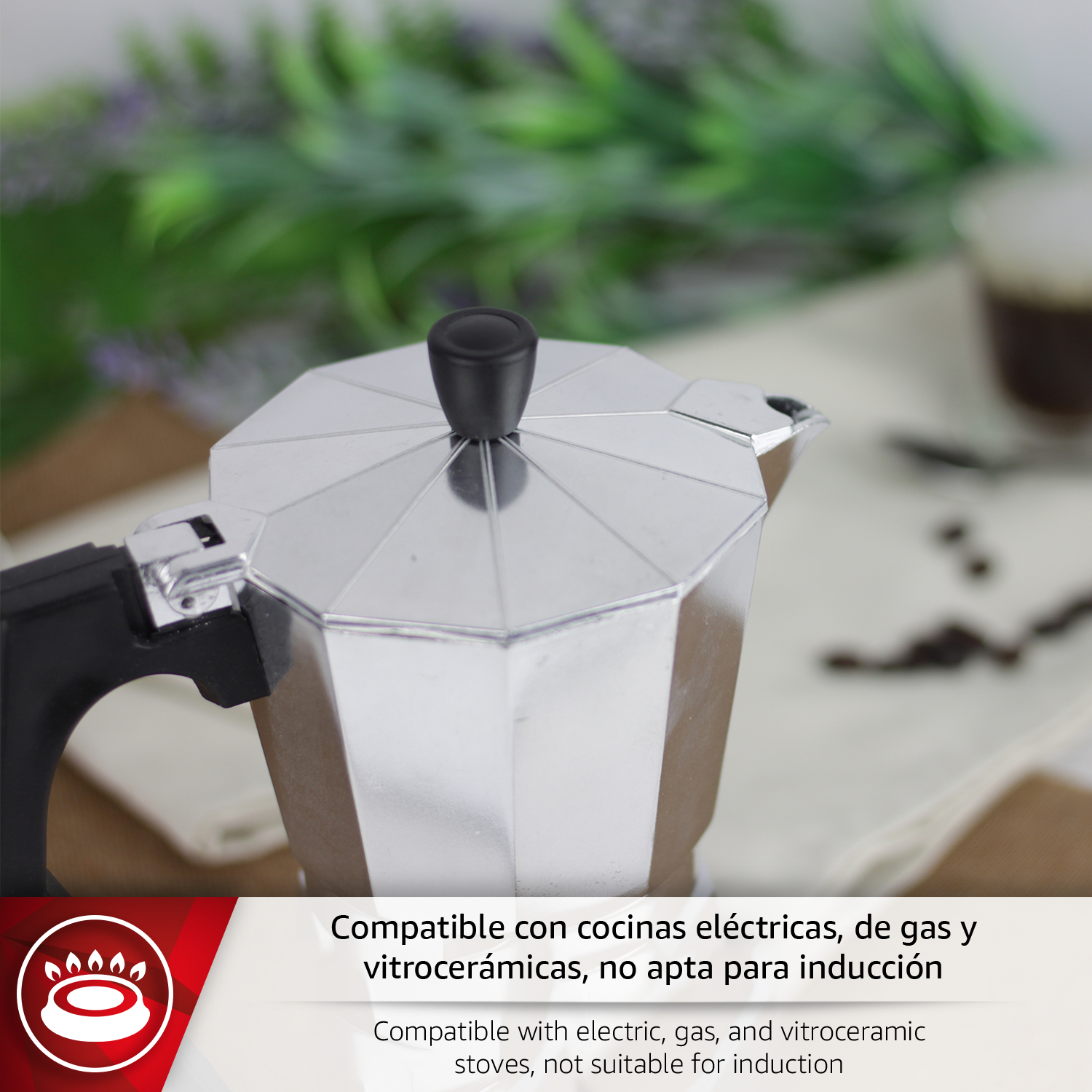 Cafetera moka plateada con asa y tapa negras, sobre una mesa.