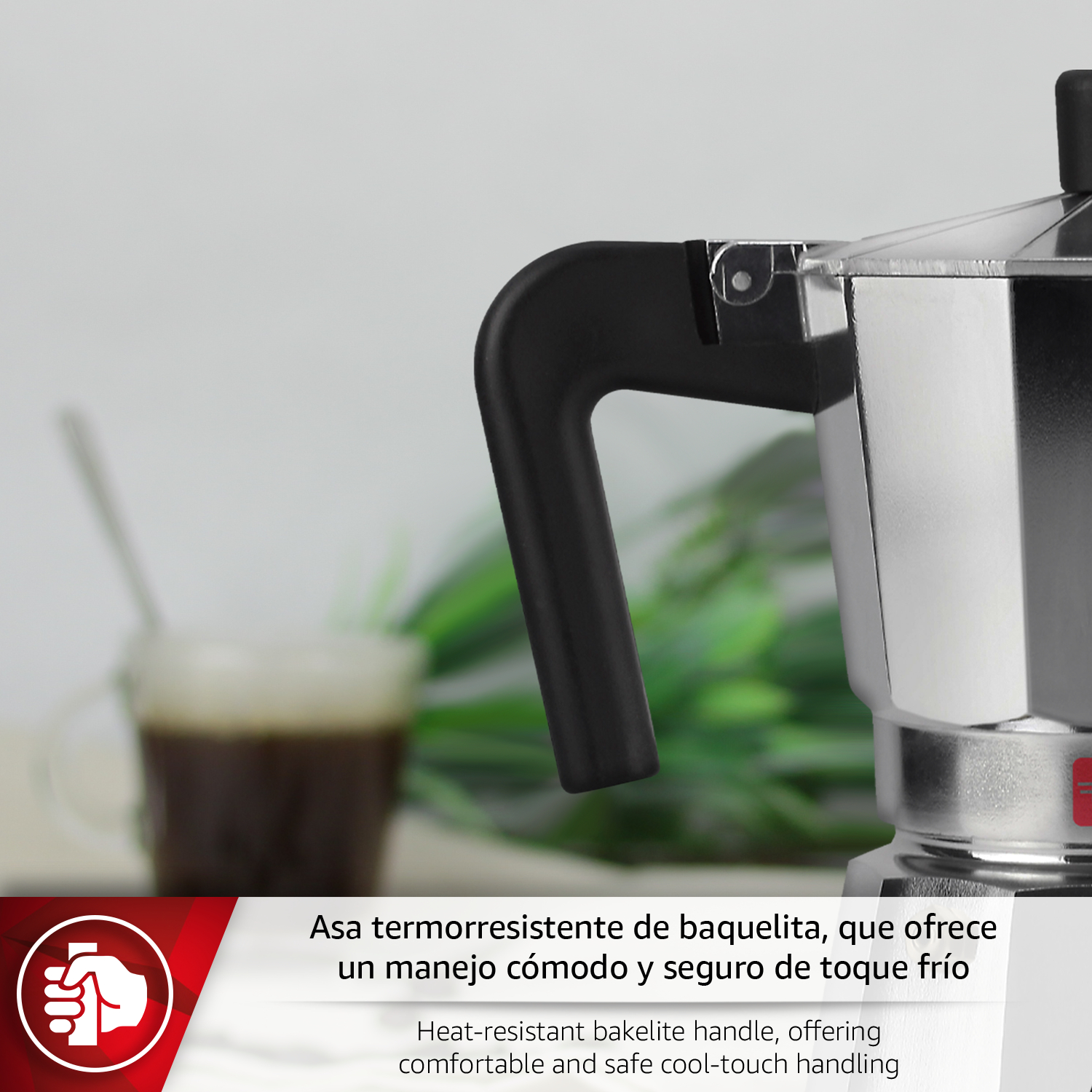Primer plano de una cafetera plateada con asa negra y una taza de café.