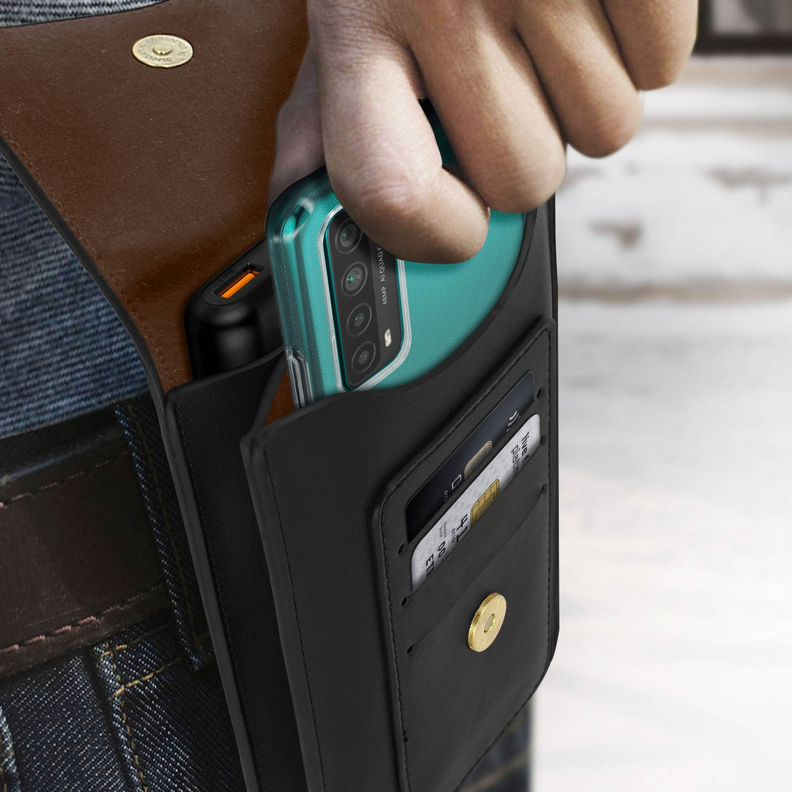 Una mano inserisce un telefono in un portafoglio nero con fessure per carte.