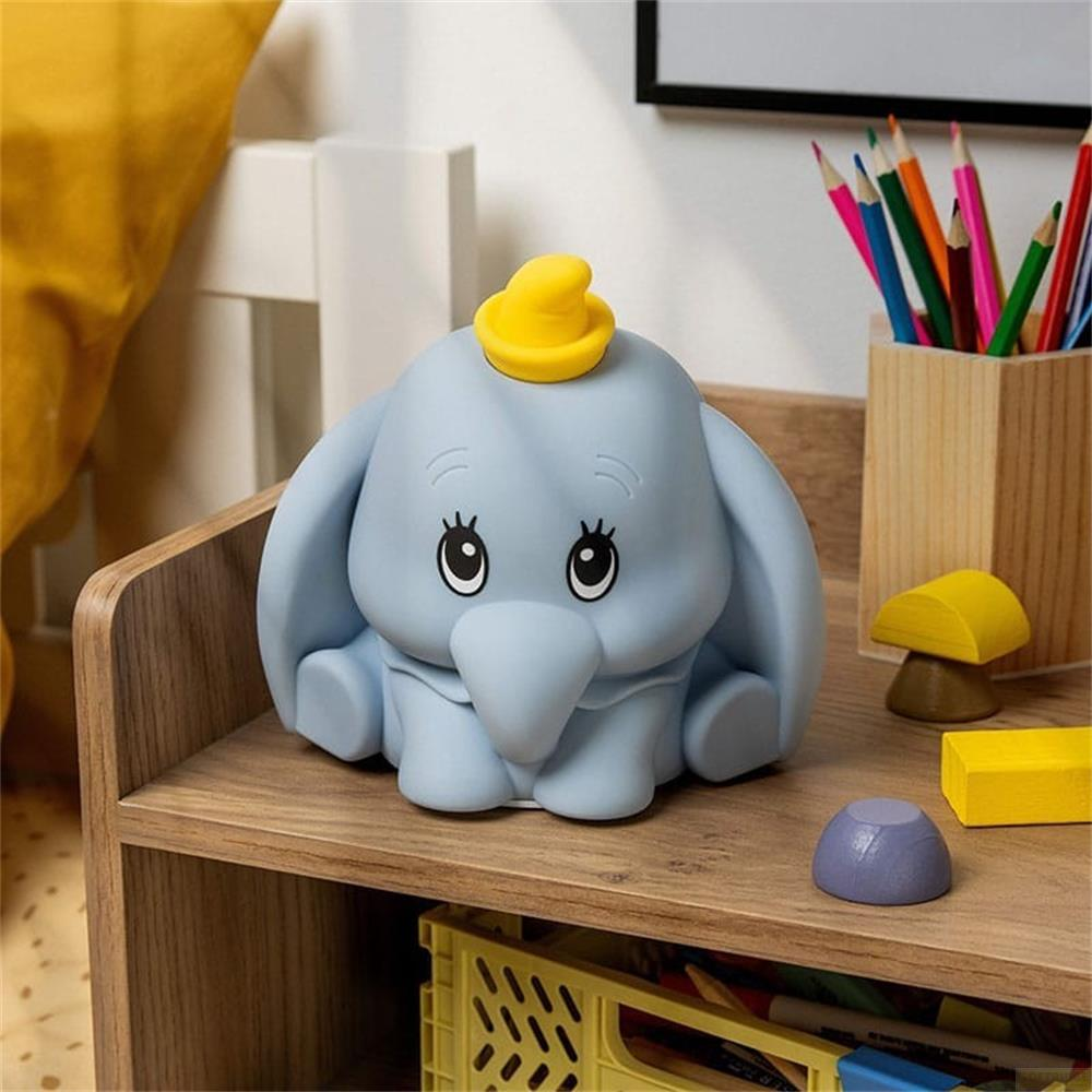 Niebieska figurka Dumbo z żółtym kapeluszem siedzi na drewnianej półce.