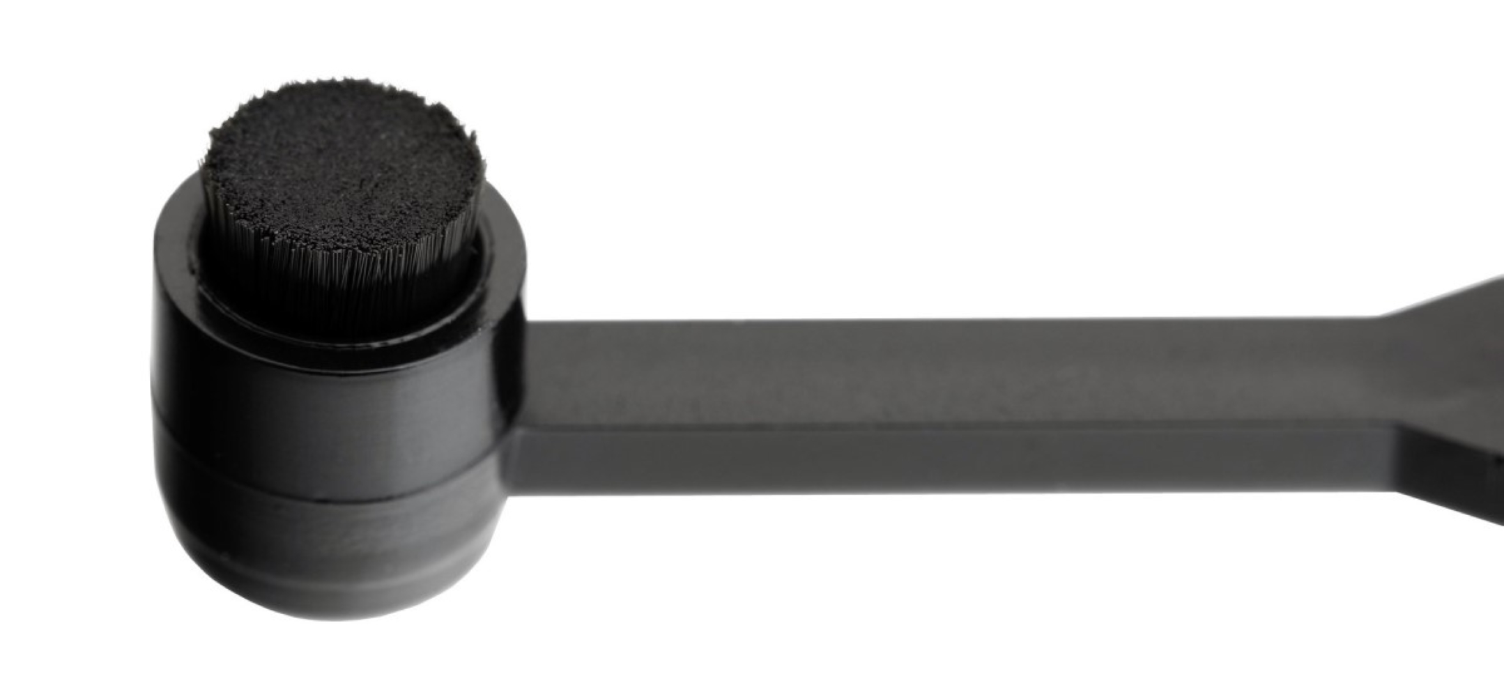 Zwarte applicator met borstelkop en handvat.