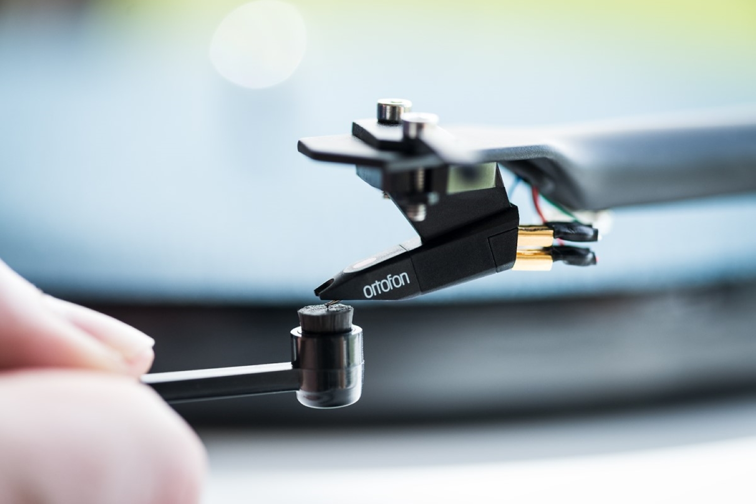 Een hand houdt een cartridge boven een plaat.