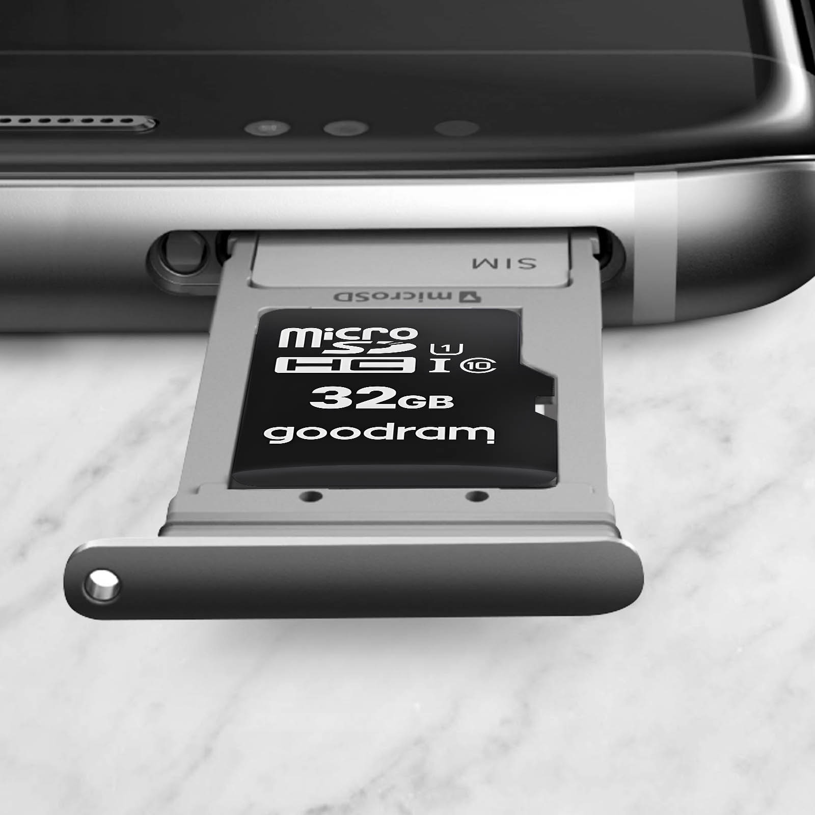 Eine 32GB microSD-Karte wird in einen SIM-Schacht eines Smartphones eingesetzt. Nahaufnahme.